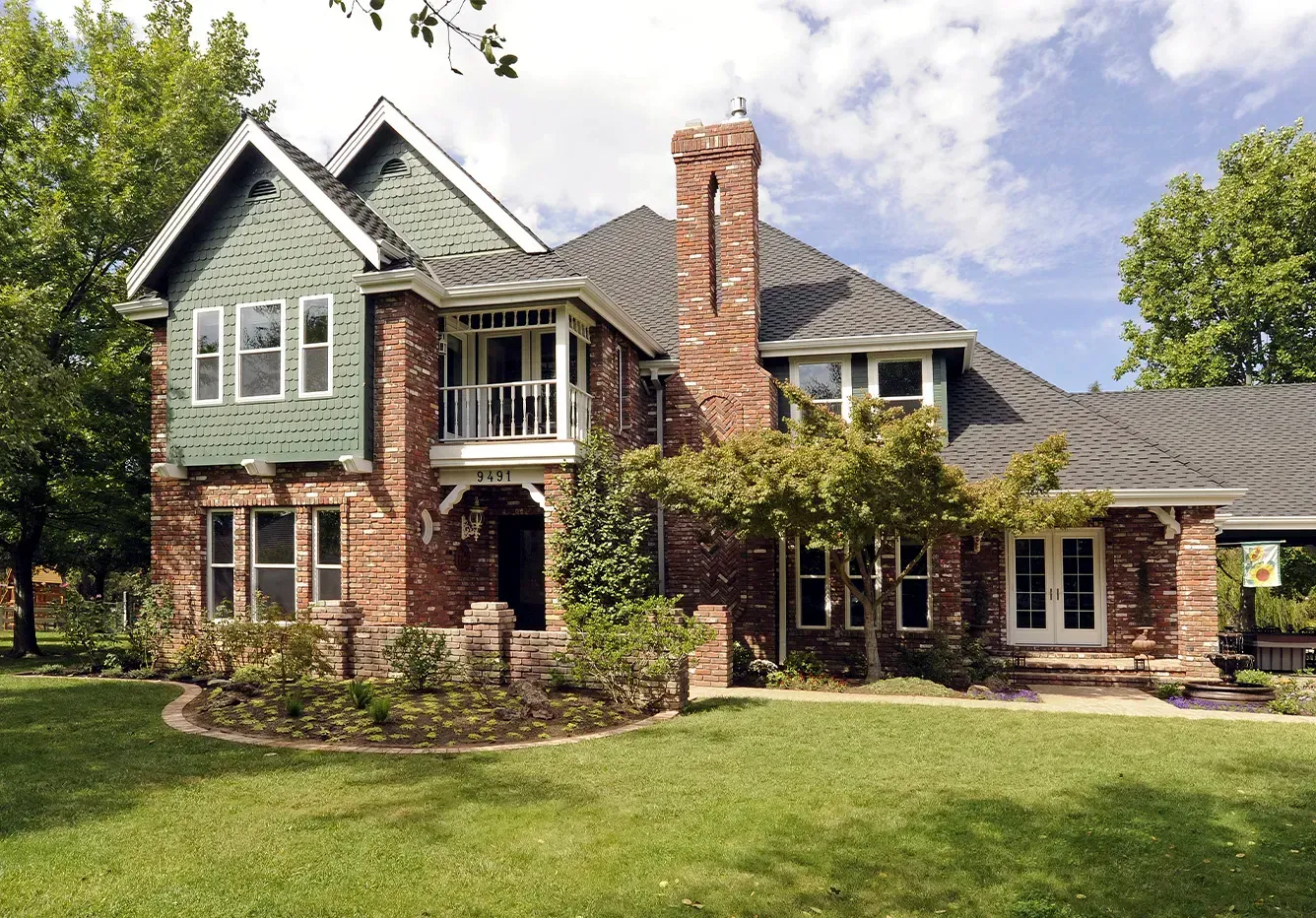 A large brick house with a green roof