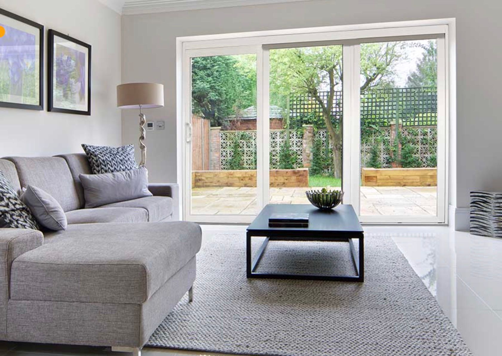 A living room with a couch , coffee table and sliding glass doors leading to a patio.