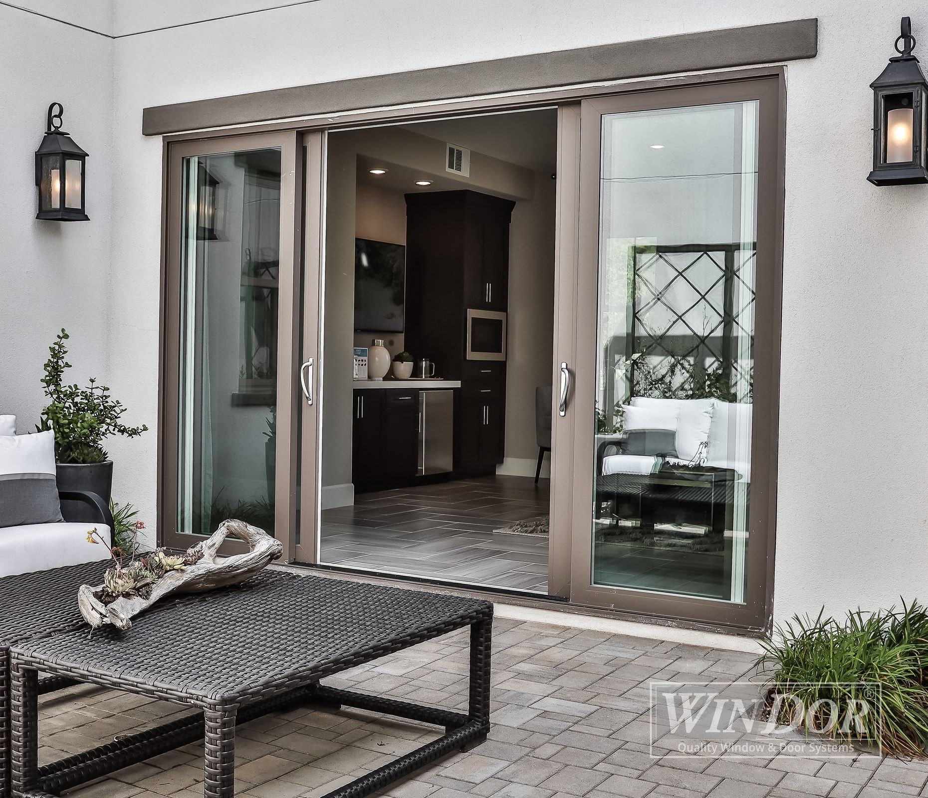 Sliding glass doors open to a living room with a table and chairs