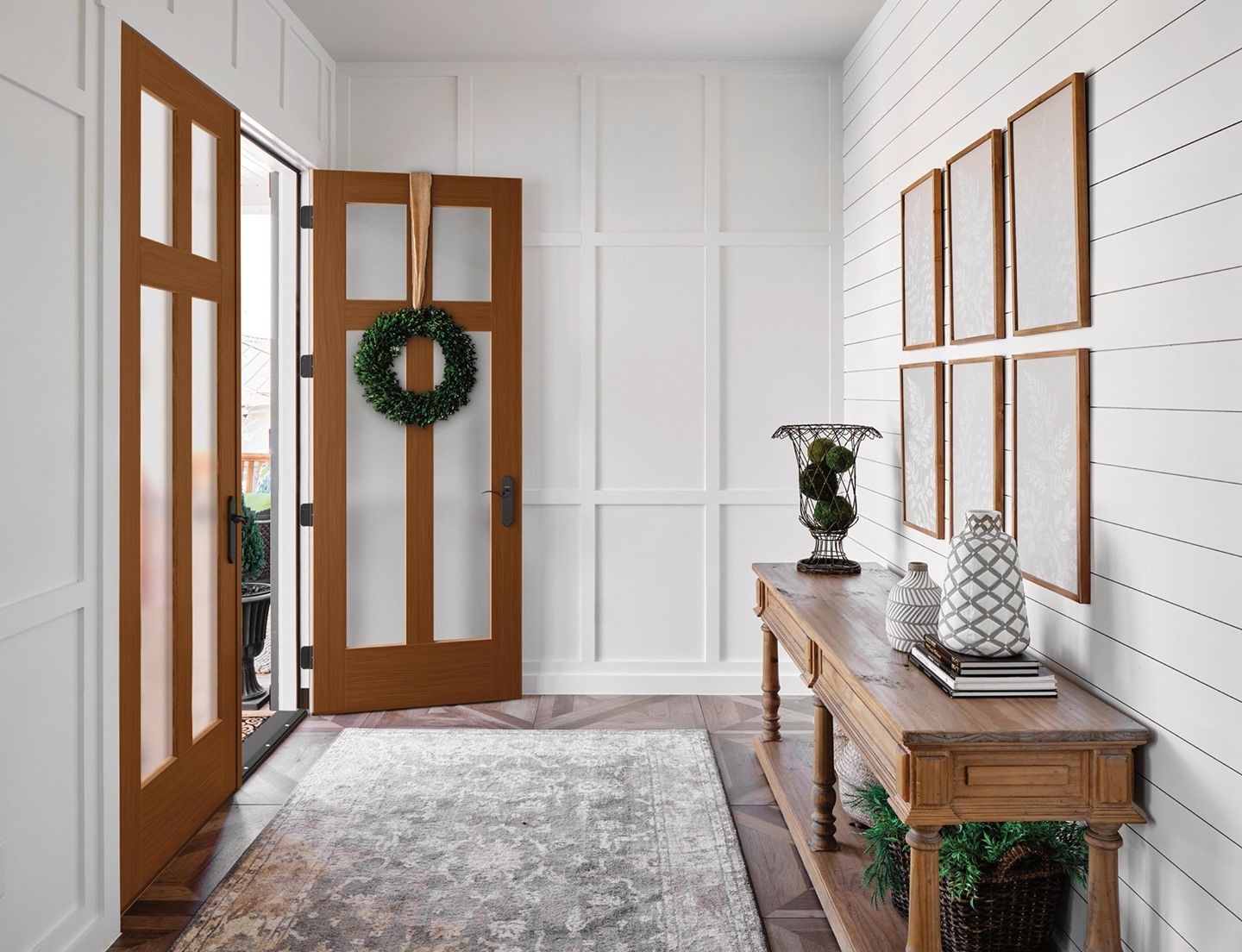 A hallway with a table and a wreath on the door.