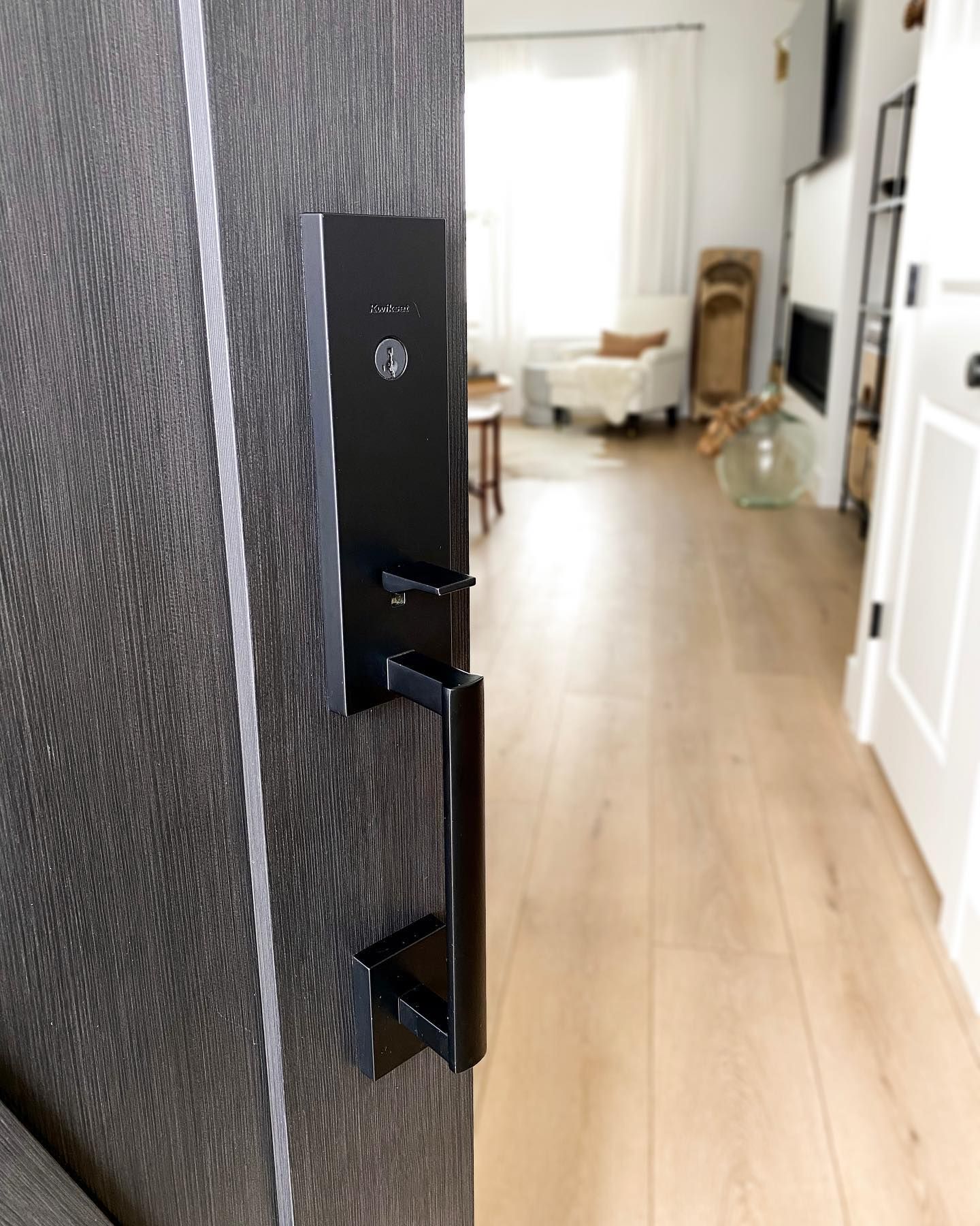 A black door with a welcome mat in front of it