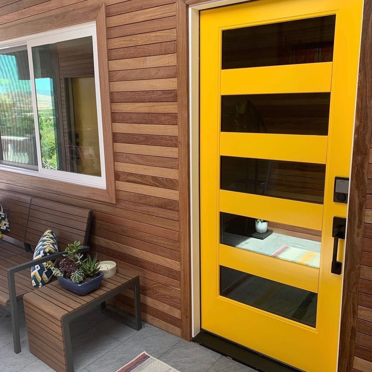 A yellow door with a wooden wall behind it