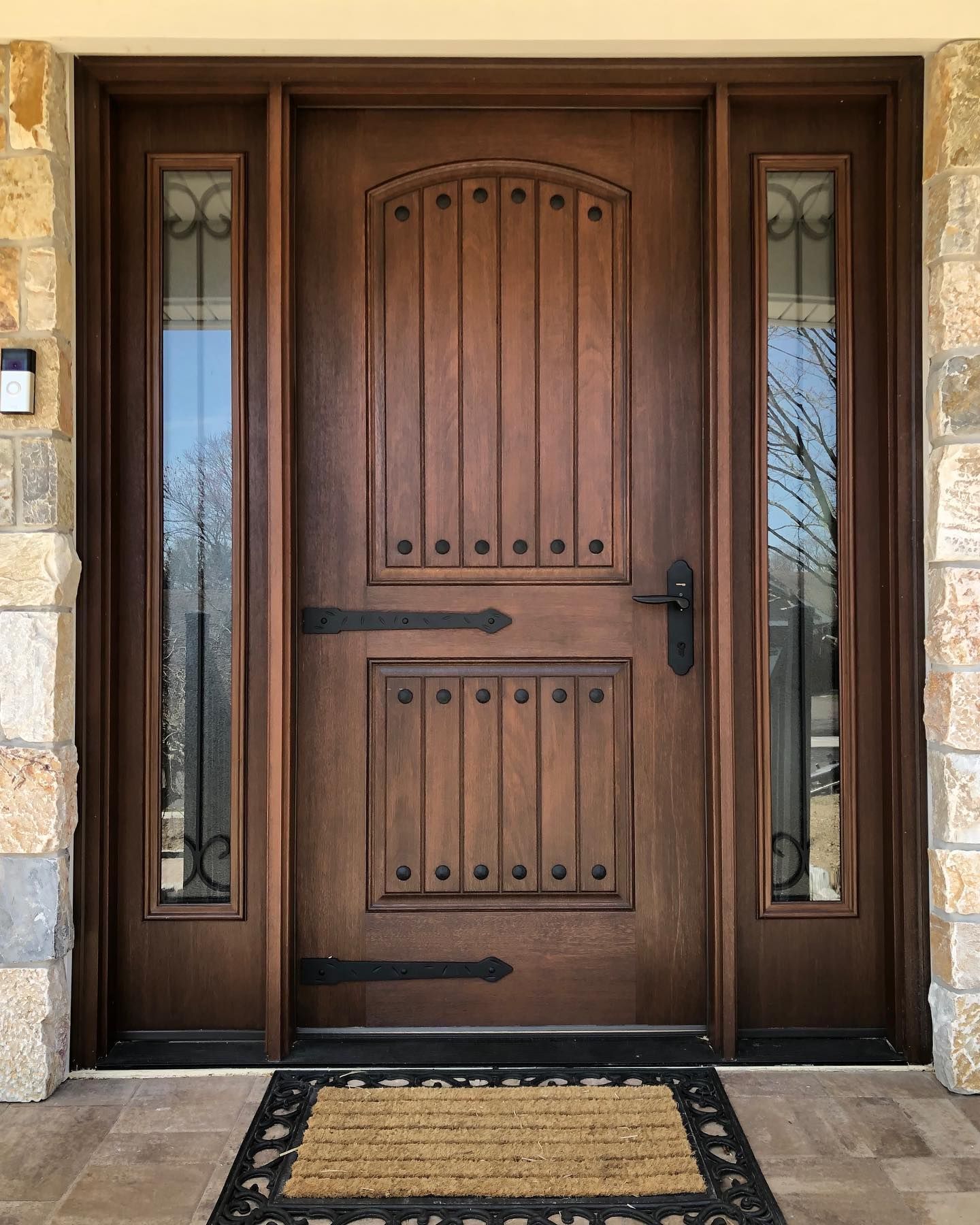 A wooden door with a welcome mat in front of it