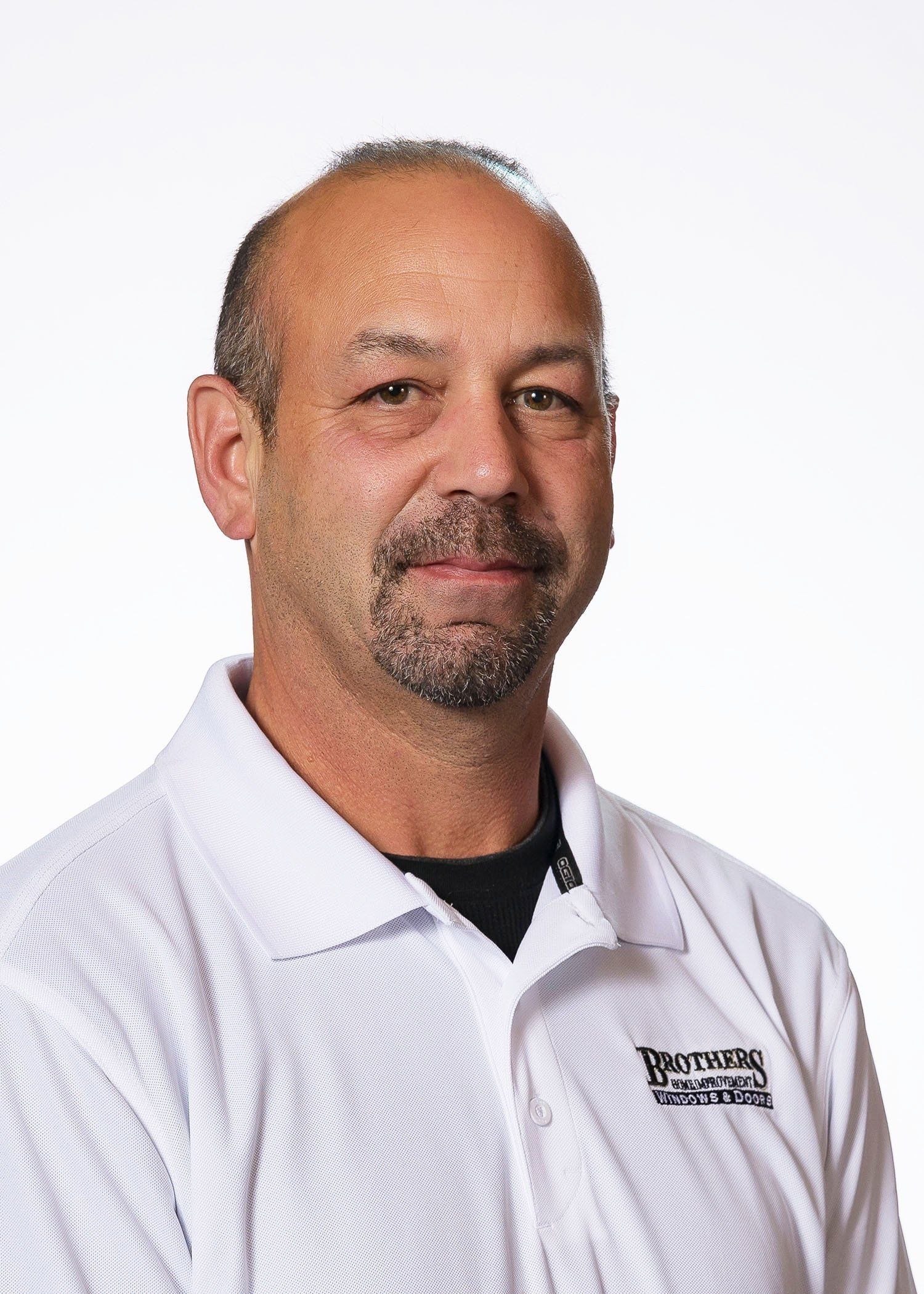 A man with a beard is wearing a white shirt.