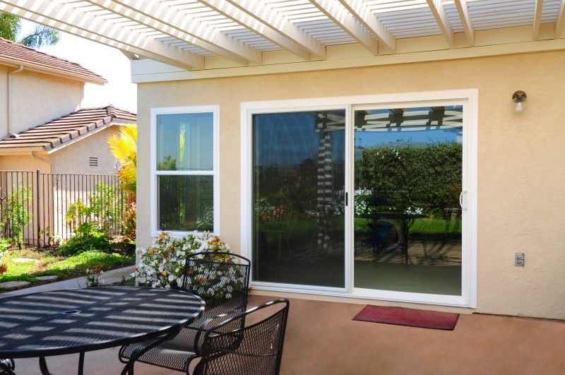 A patio with a table and chairs and a sliding glass door
