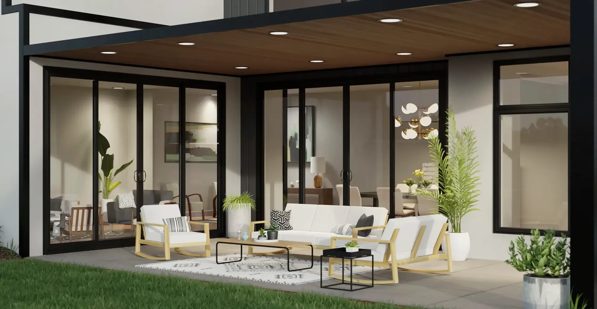 A patio with a couch , chairs , and a table in front of a house.