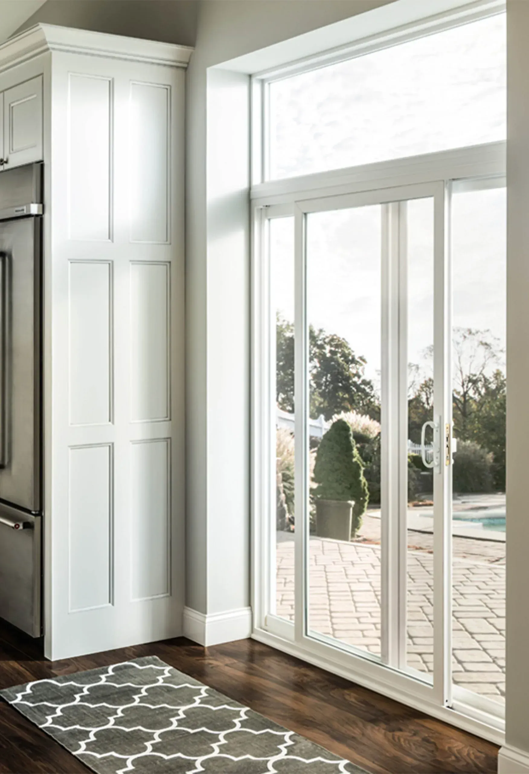 A kitchen with sliding glass doors and a rug on the floor.