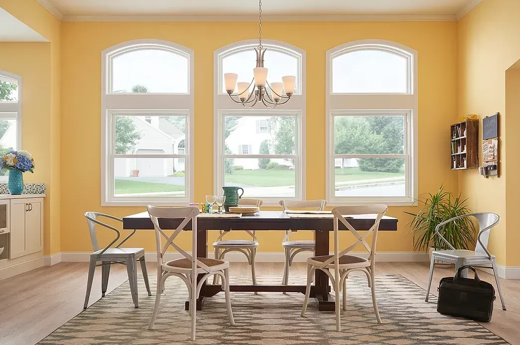 A dining room with a table and chairs and yellow walls.