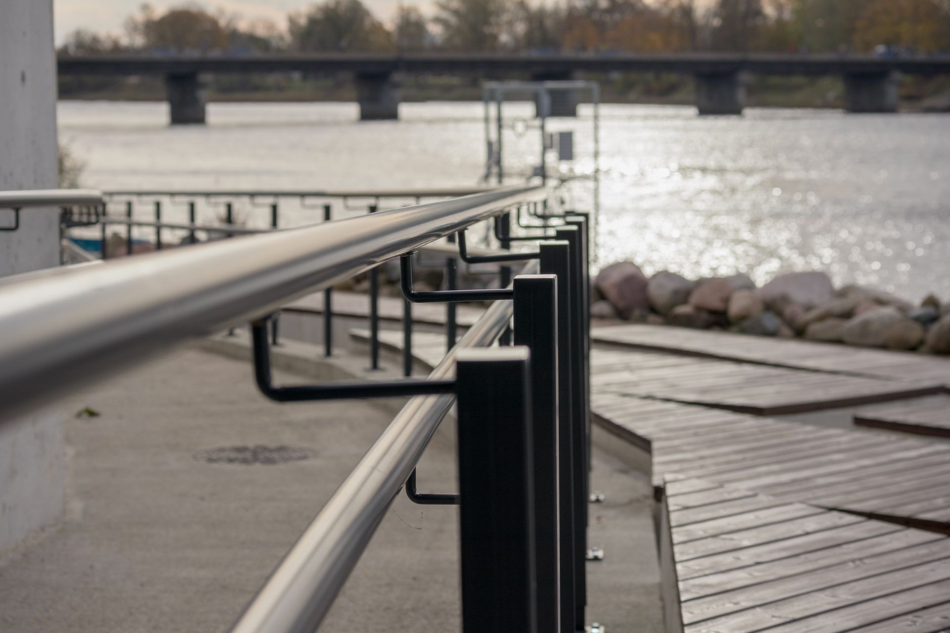 A railing along a dock with a bridge in the background