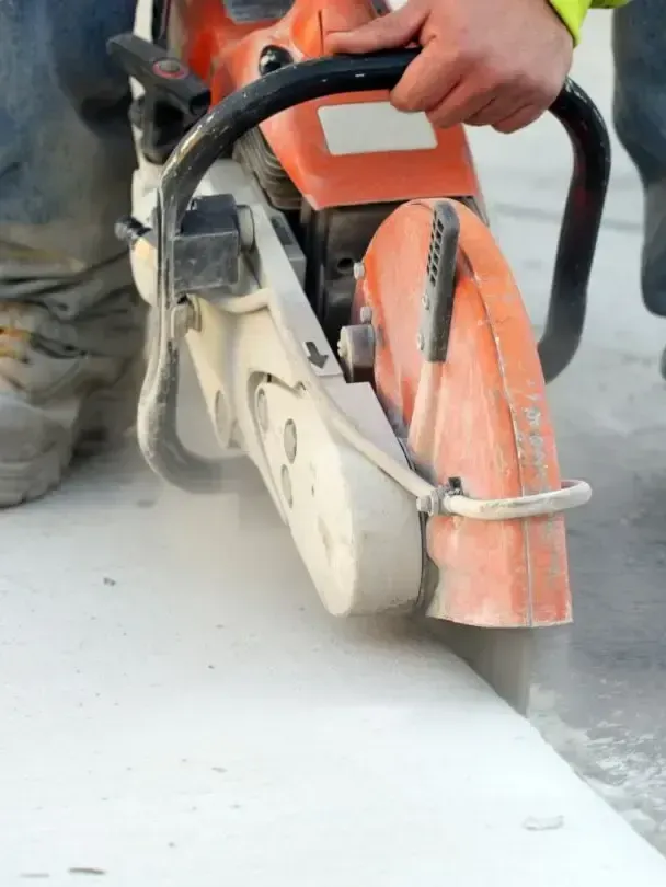 A person is using a chainsaw to cut concrete