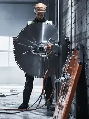A man is cutting a wall with a circular saw.