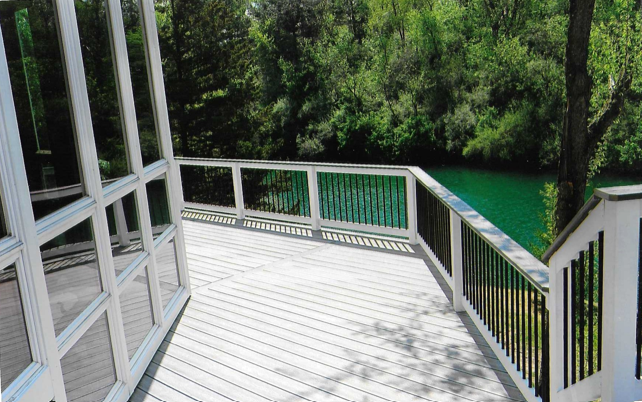 A deck with a view of a lake and trees