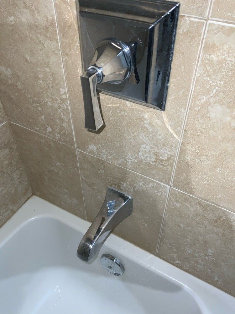 A bathroom with a bathtub and a shower faucet