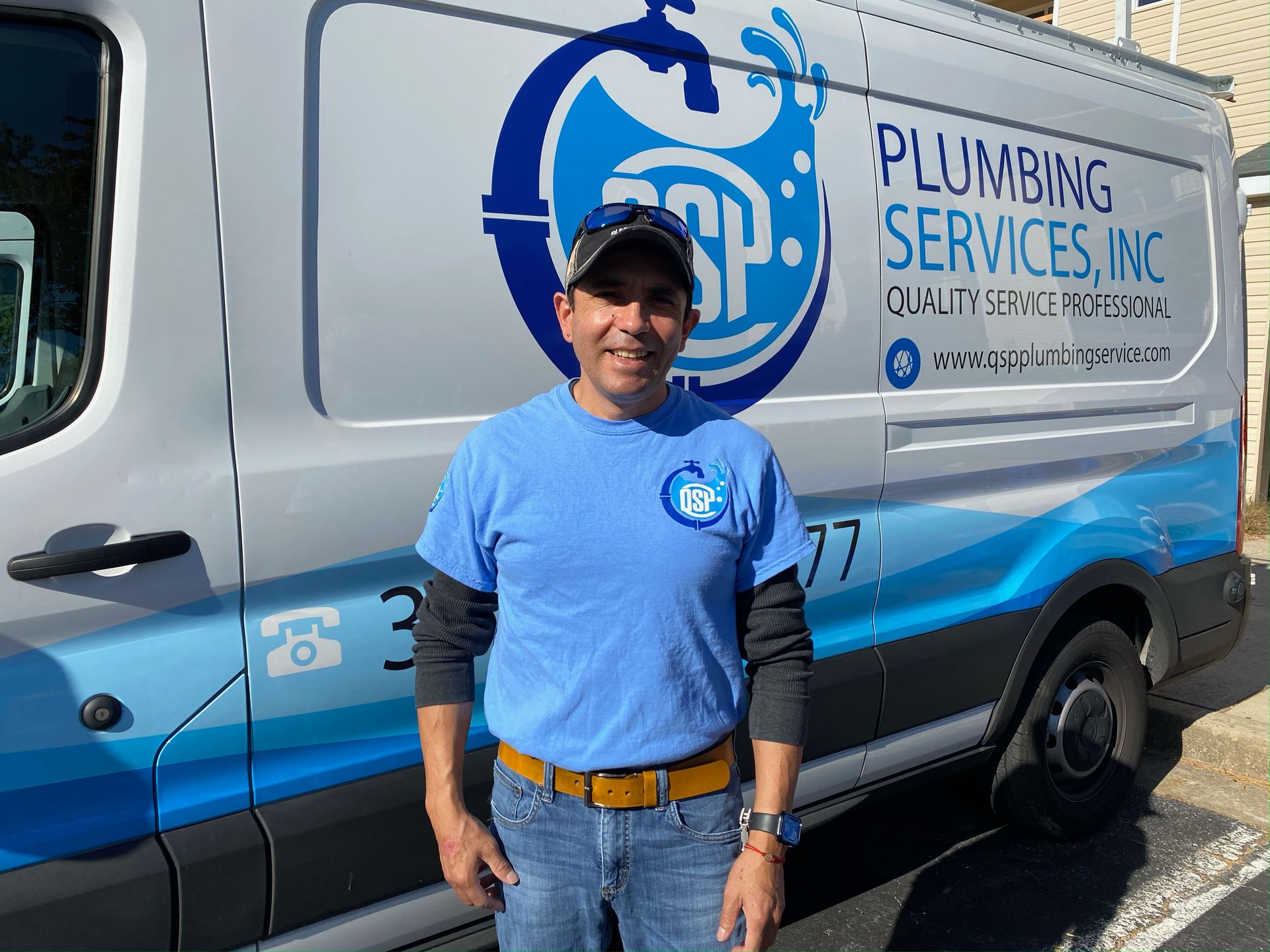 A man is standing in front of a plumbing services van.