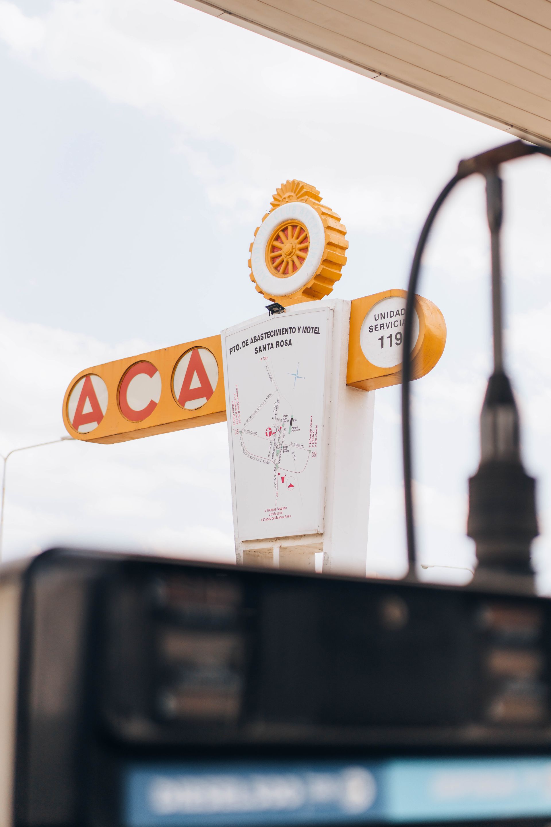 ACA gas station sign, yellow and white, with a price of 119.  Sky in the background.