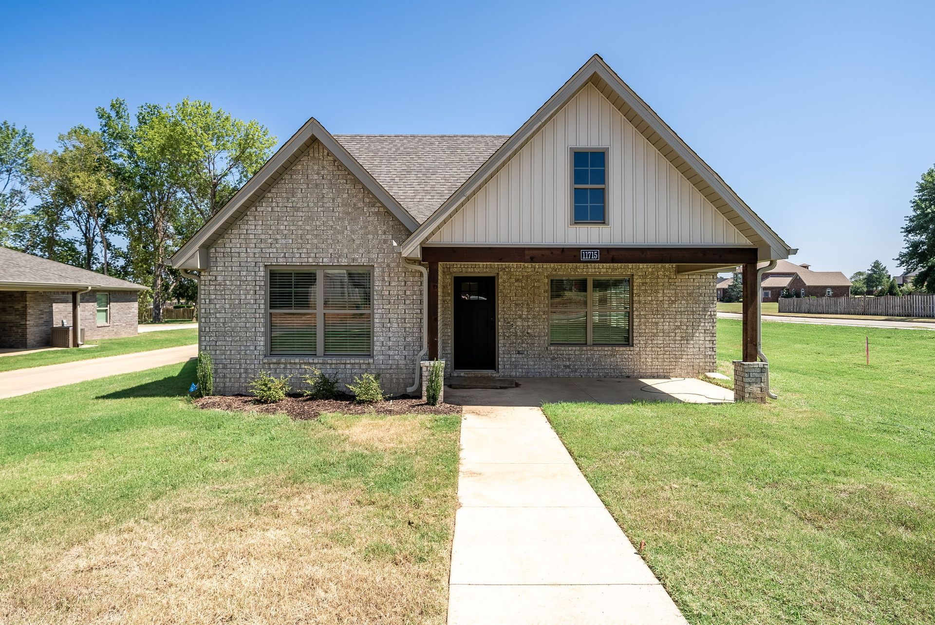 A brick house with a concrete walkway leading to it