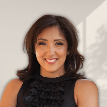 A woman wearing a black ruffled top smiles for the camera