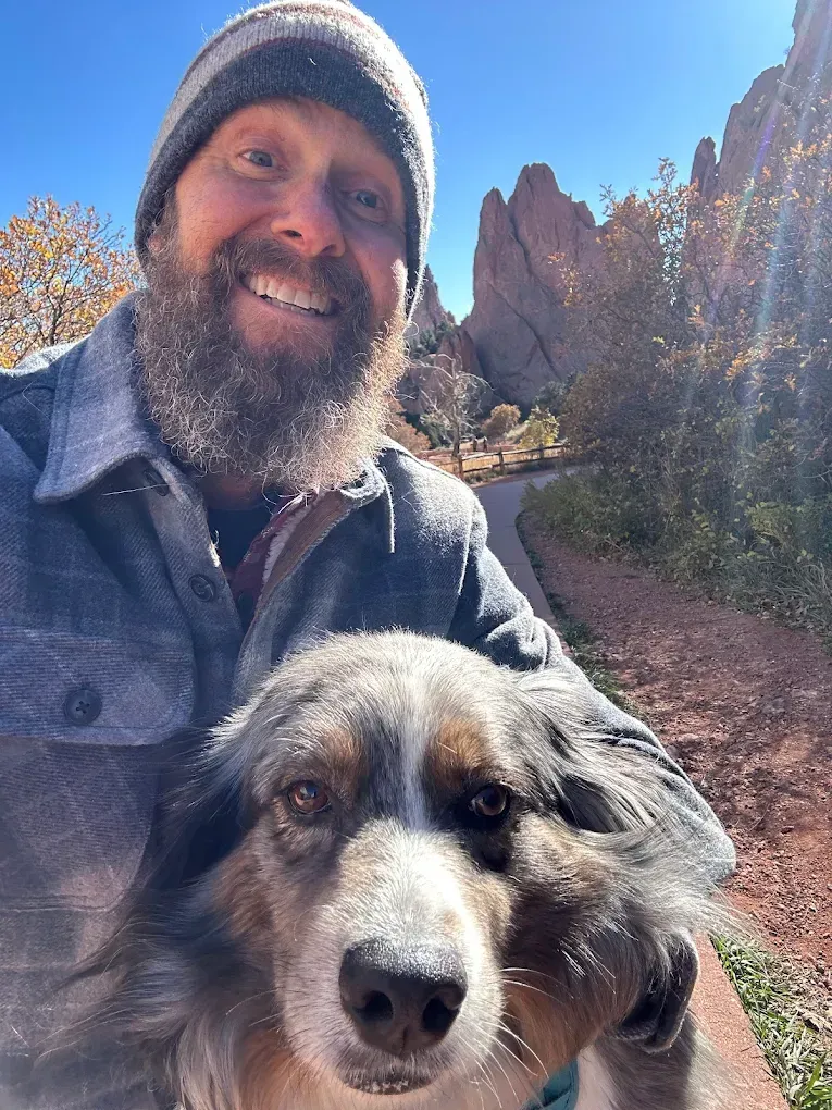 A man and a woman are sitting on a couch talking to each other.