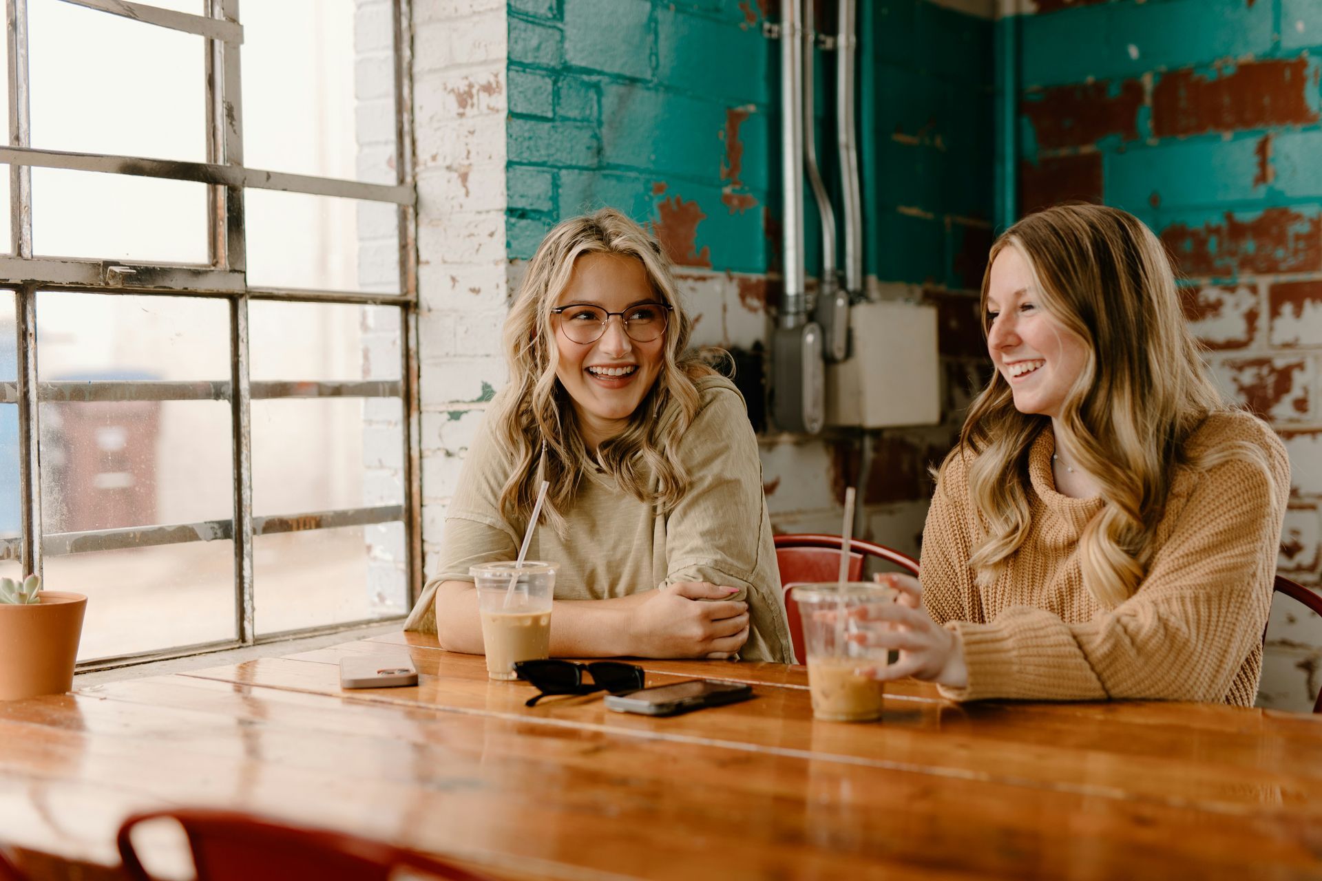 two women sitting at a table with drinks
