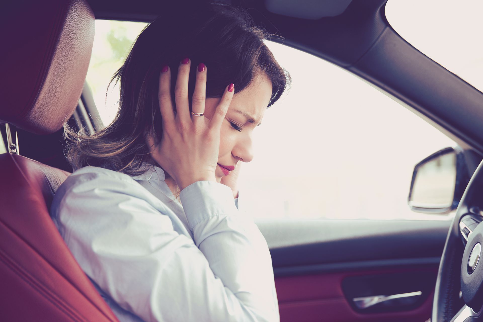 A woman holding her head with her hands | Woodie's Auto Service & Repair Centers