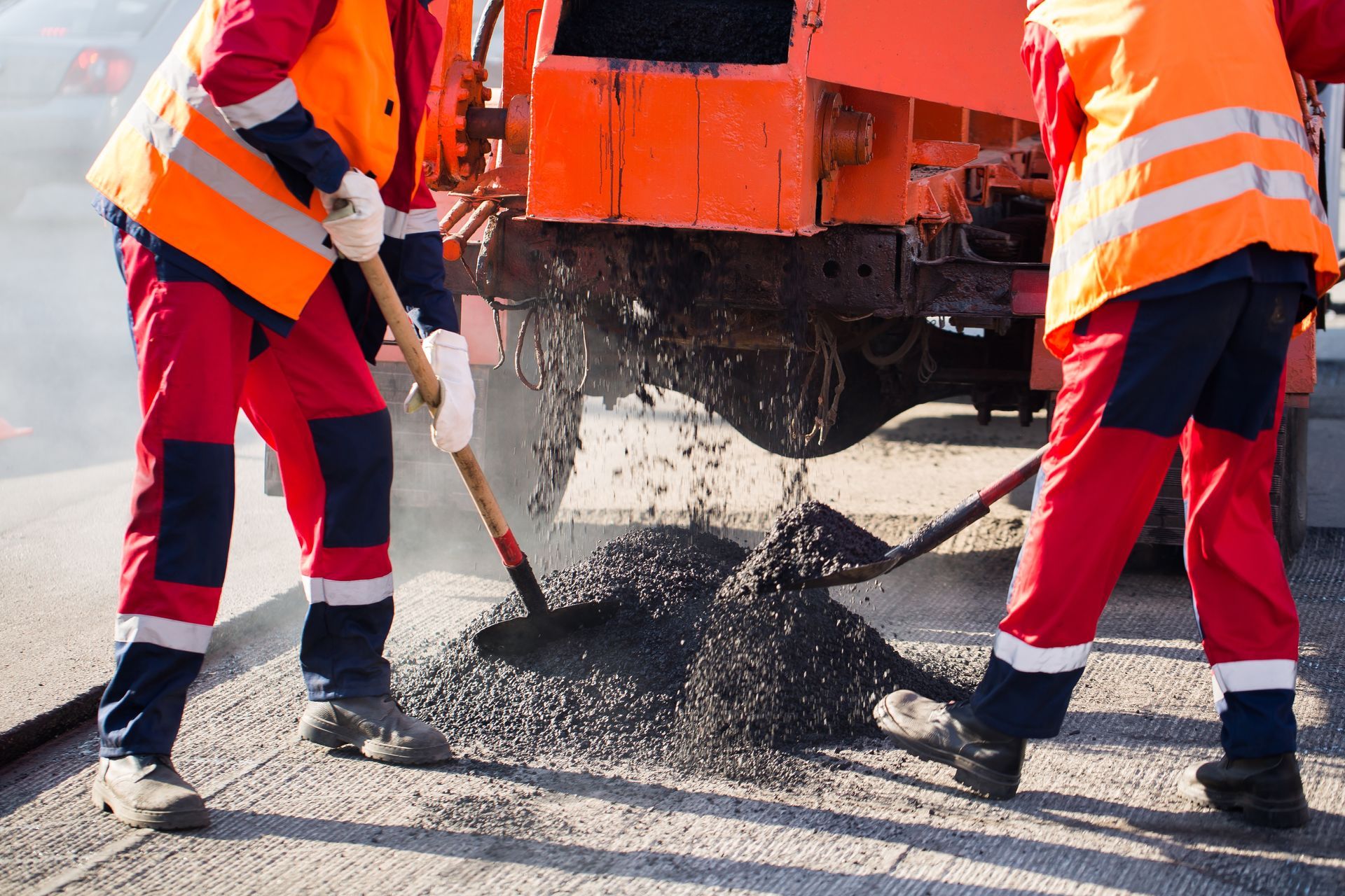 A group of construction workers are working on a road