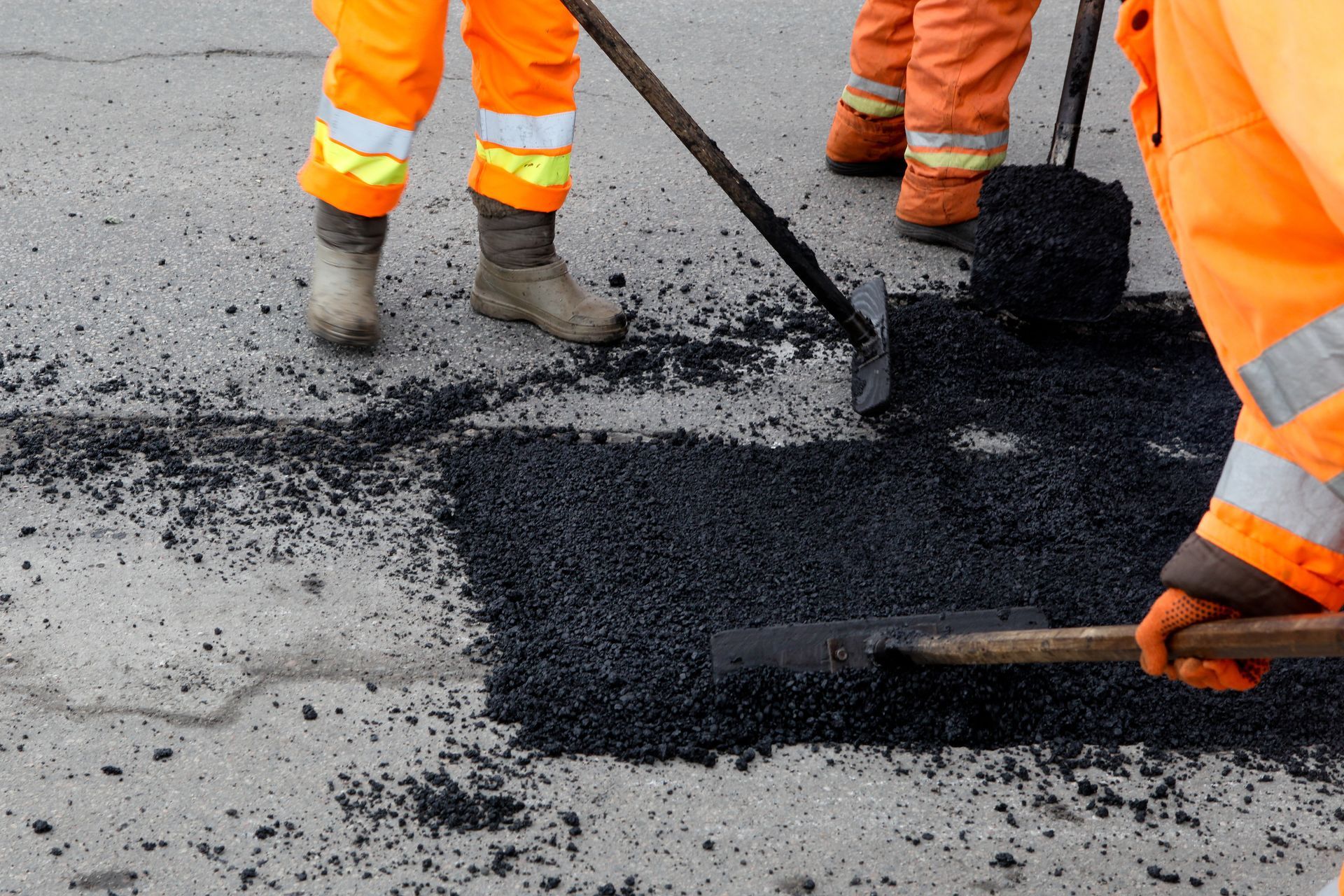 A man is spreading asphalt on the ground