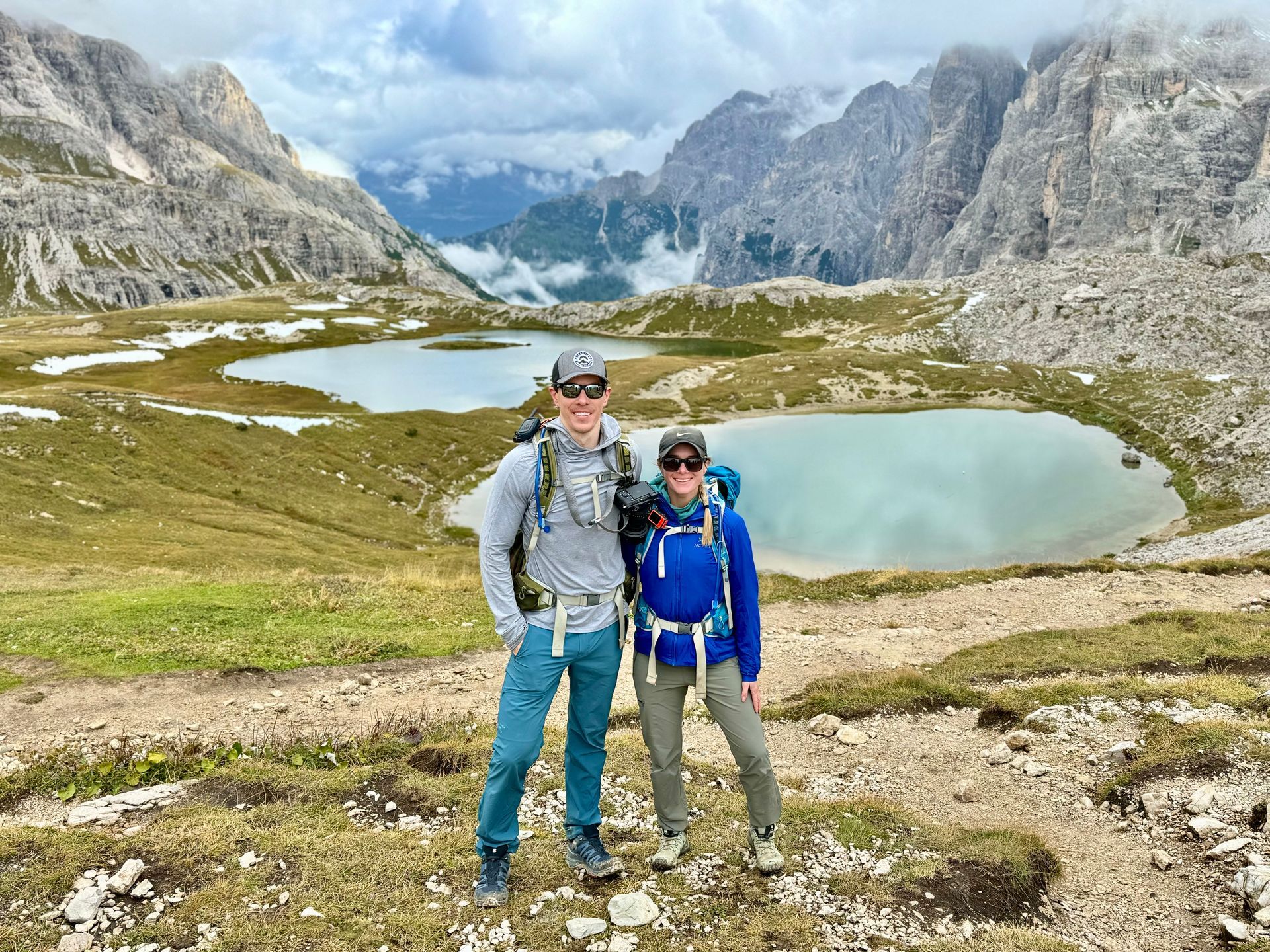 A man and a woman are posing for a picture on top of a mountain.