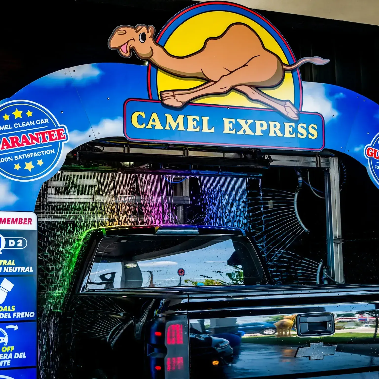 A black truck being washed at the Camel Express car wash.