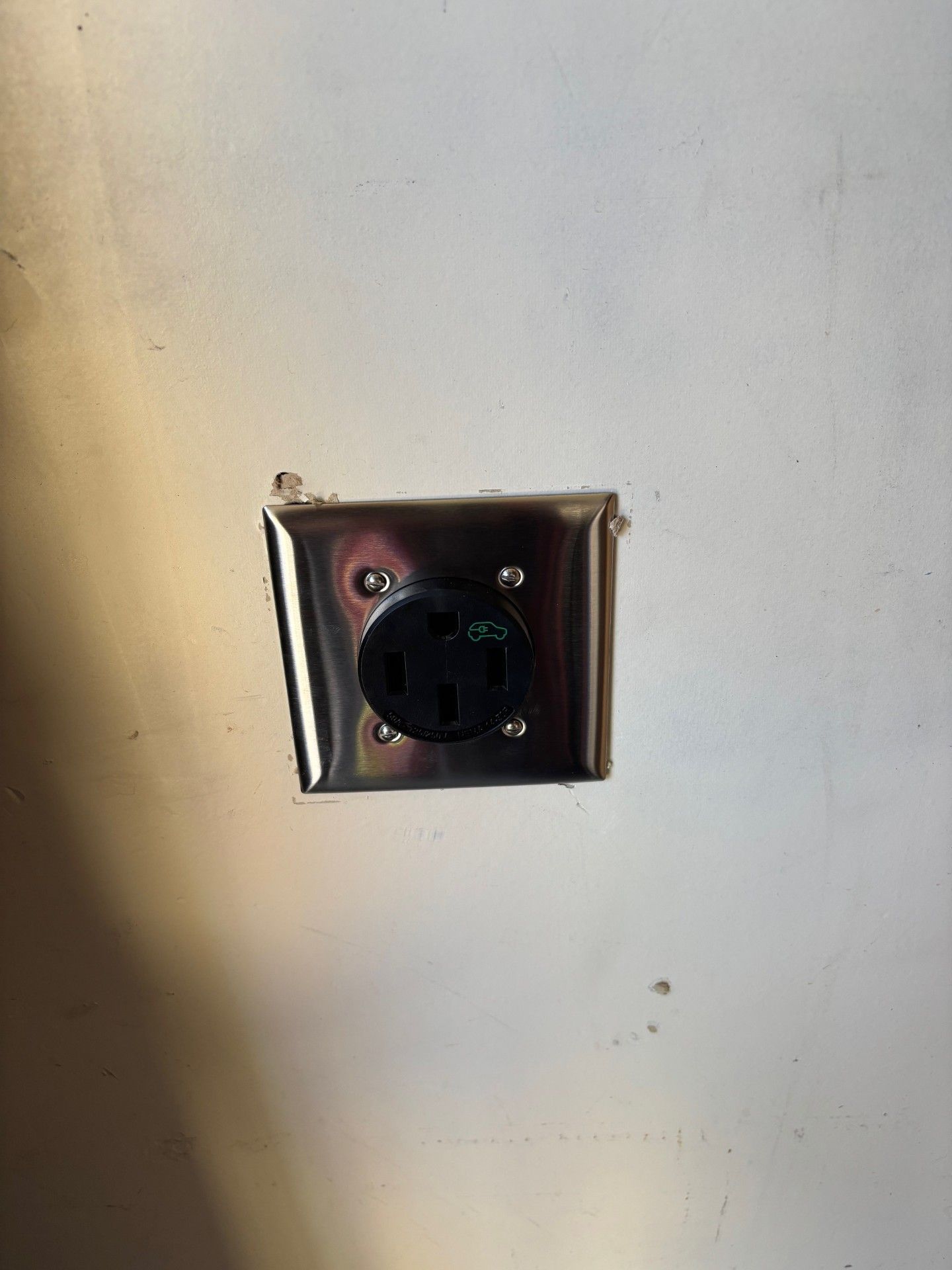 Stainless steel electrical outlet on a wall.