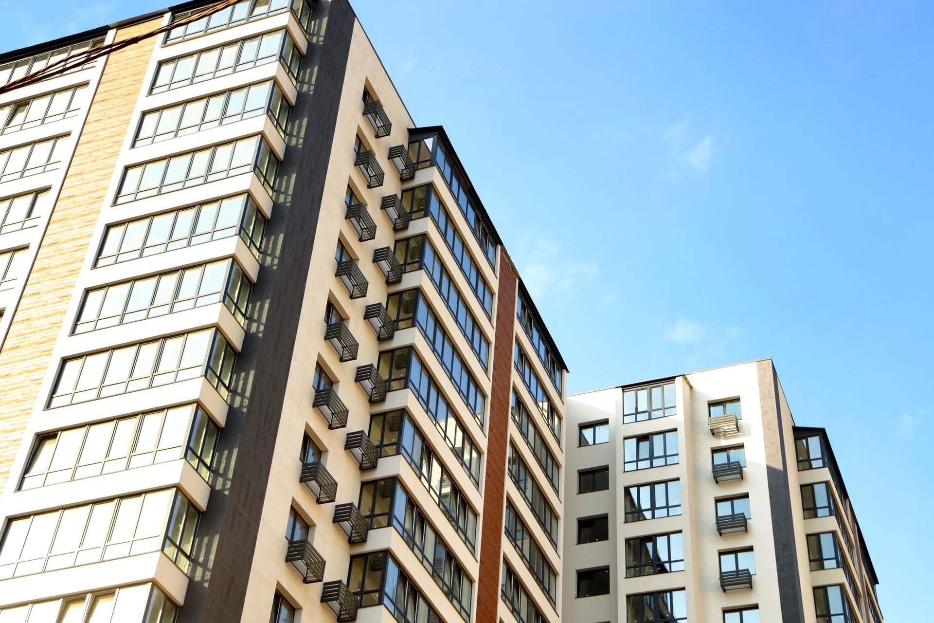 Multi-story apartment buildings against a blue sky. 