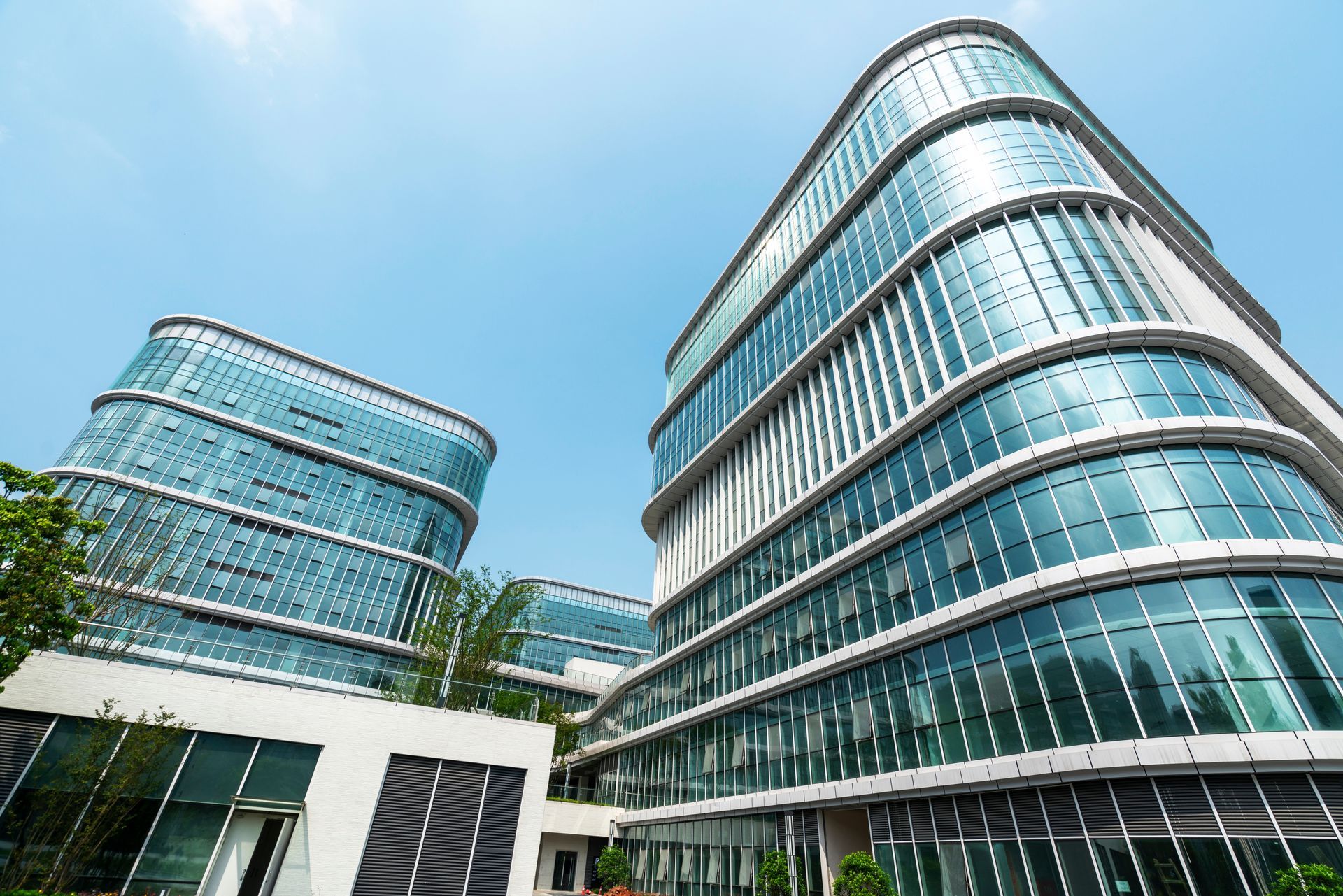 Modern glass-walled office buildings under a clear blue sky.