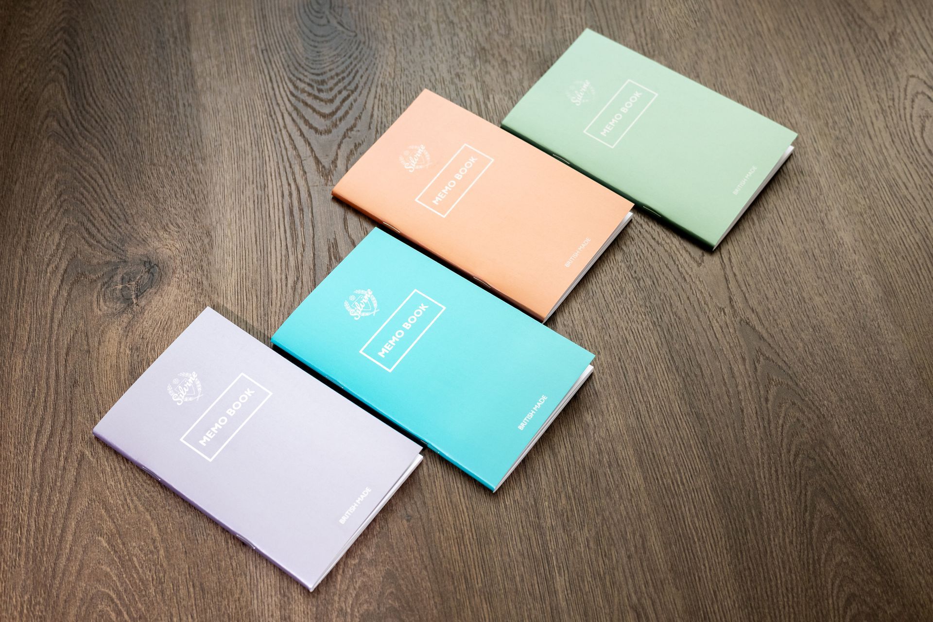 Metallic Memo Notebooks by Silvine on wood textured background.