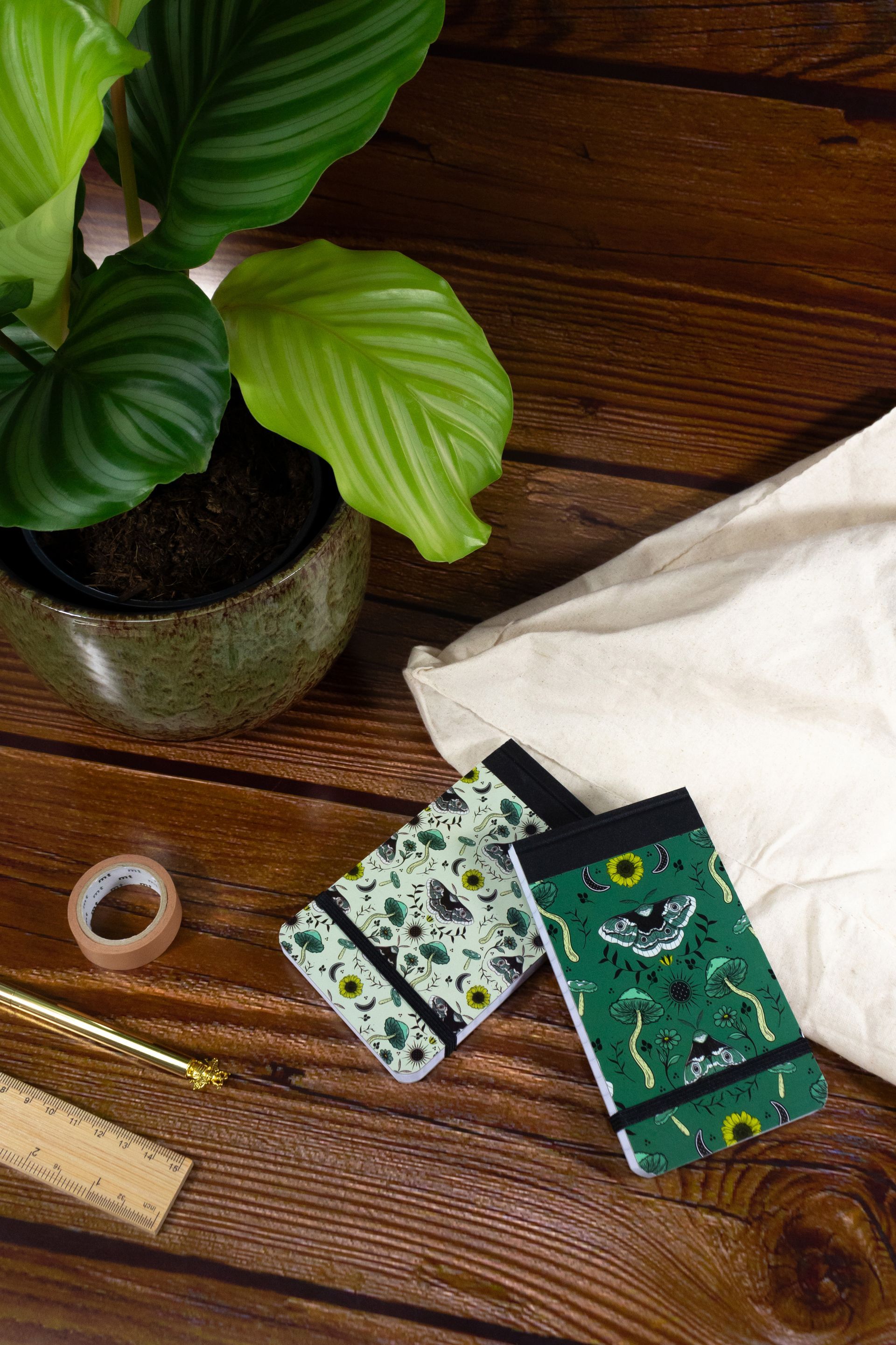 Fashion pocket notebooks by Silvine with plant and wooden textured background