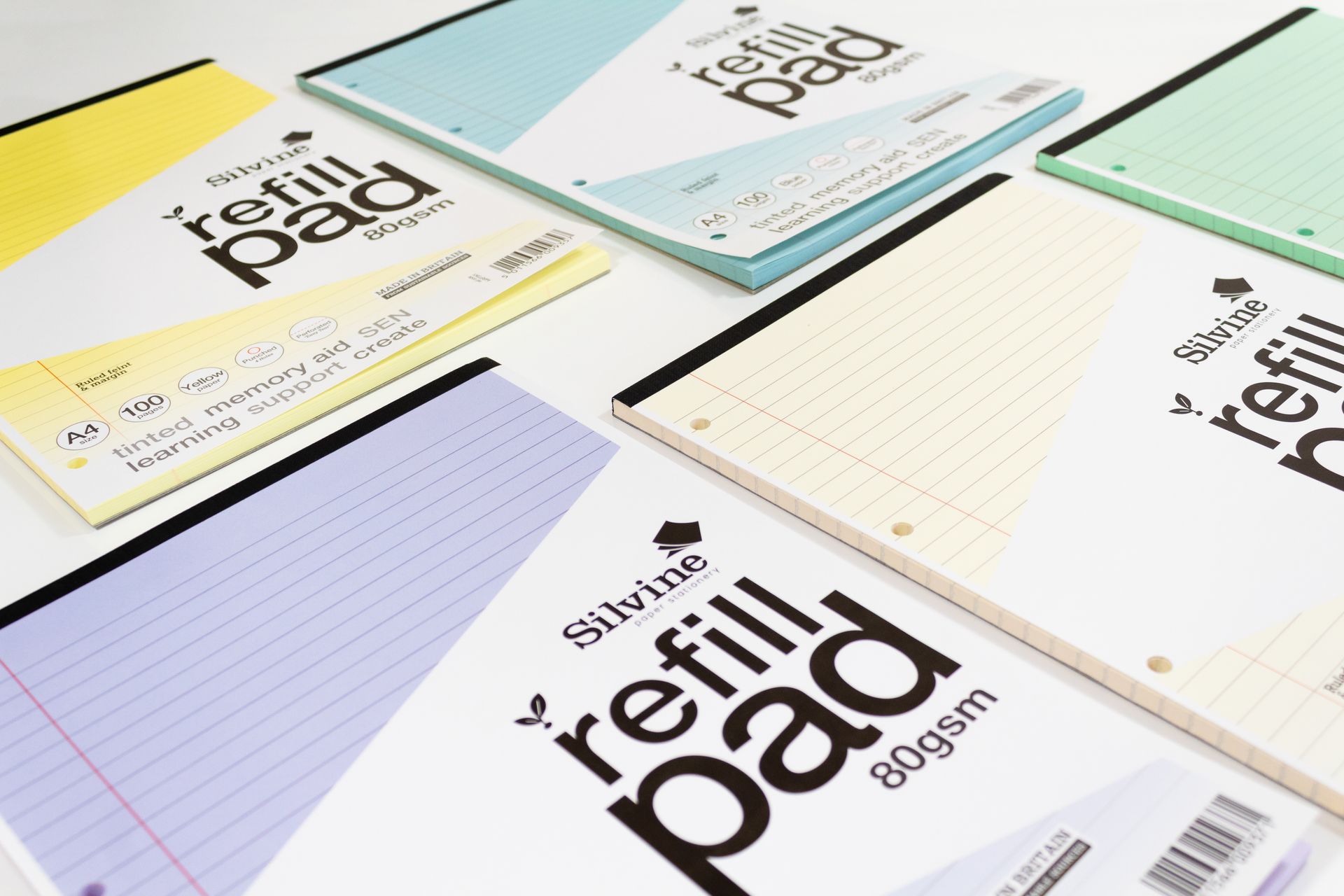 Silvine A4 Tinted Refill Pads on white background. The tints of these pads include yellow, blue, purple, cream and green.