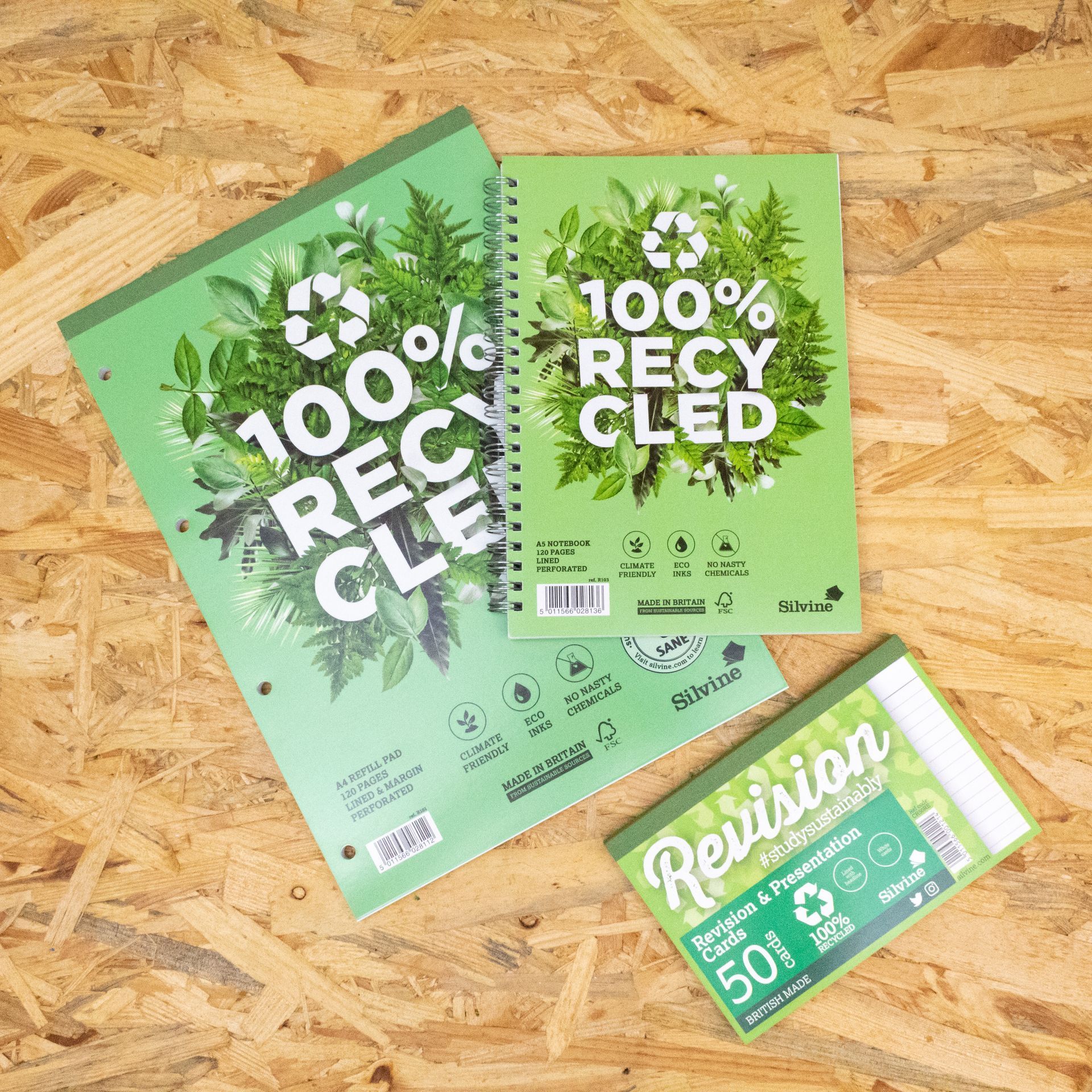 100% recycled refill pad, notebook and record cards on a wood chip board background.
