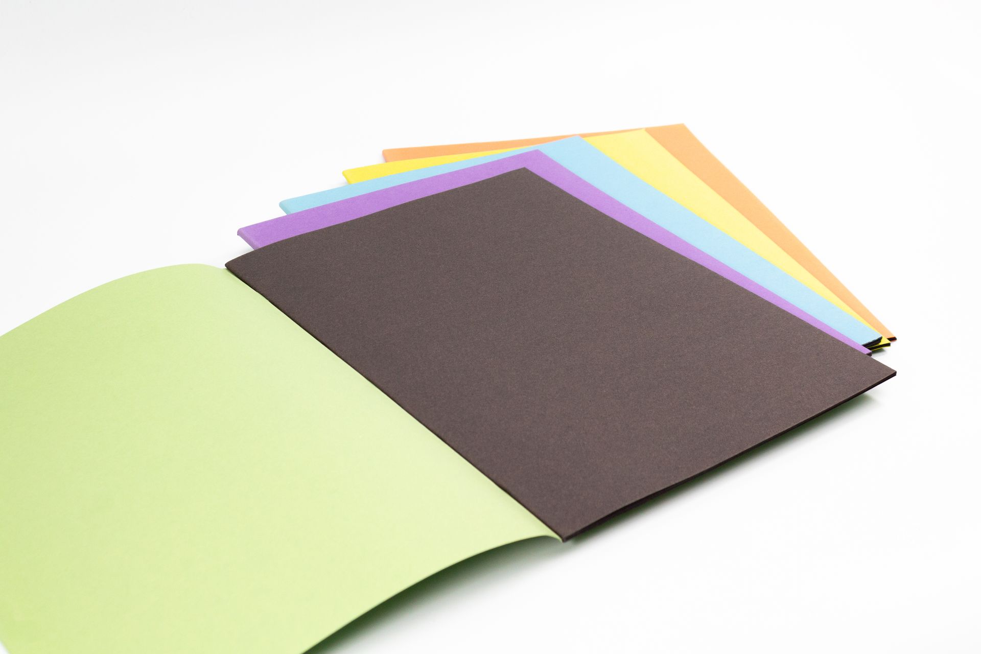 A variety of Silvine scrapbooks with assorted covers on white background. The top one is open to reveal black paper inside