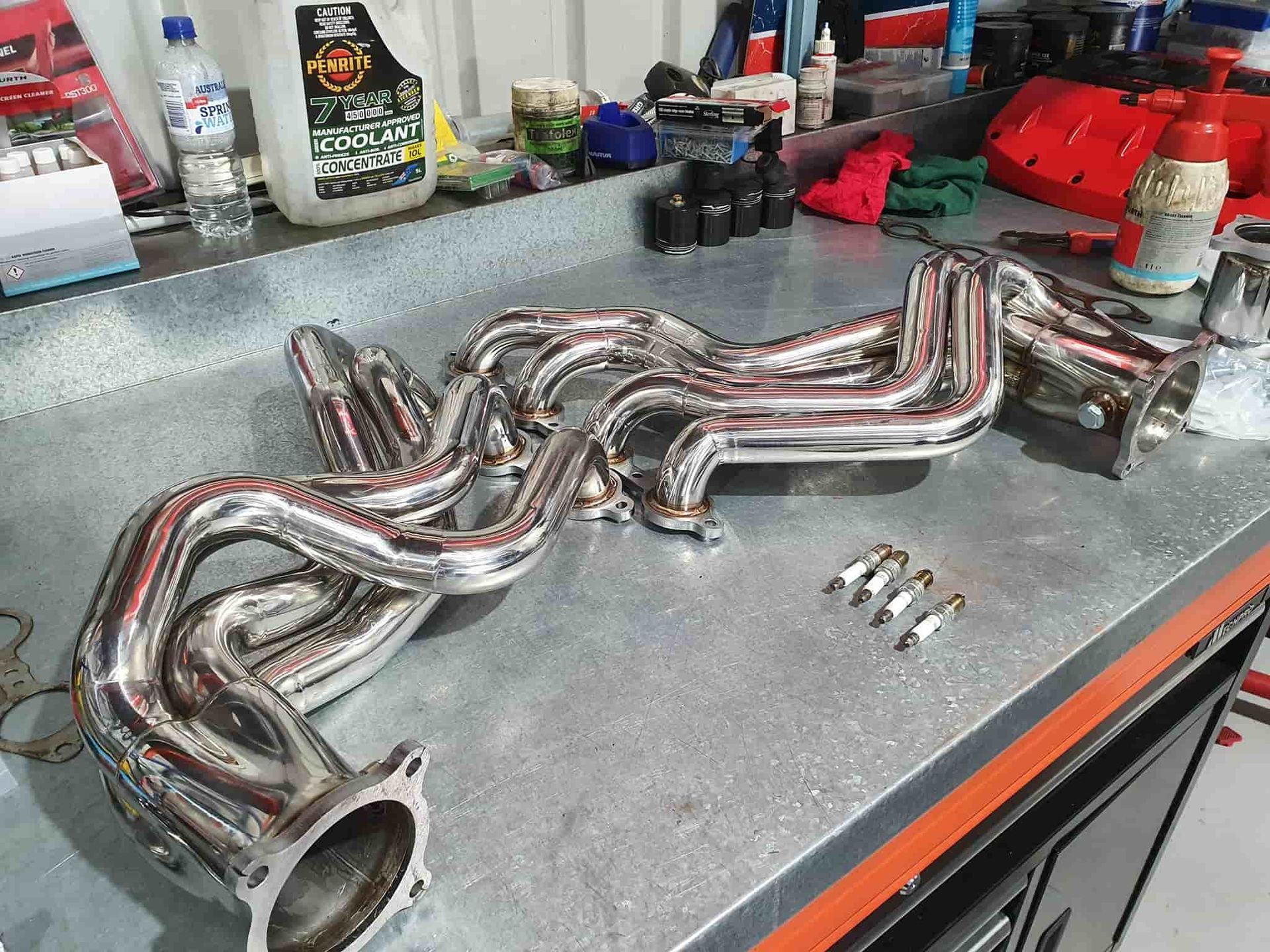 A Stainless Steel Exhaust Pipe is Sitting on a Metal Table — OSP Automotive & Marine In Grafton, NSW