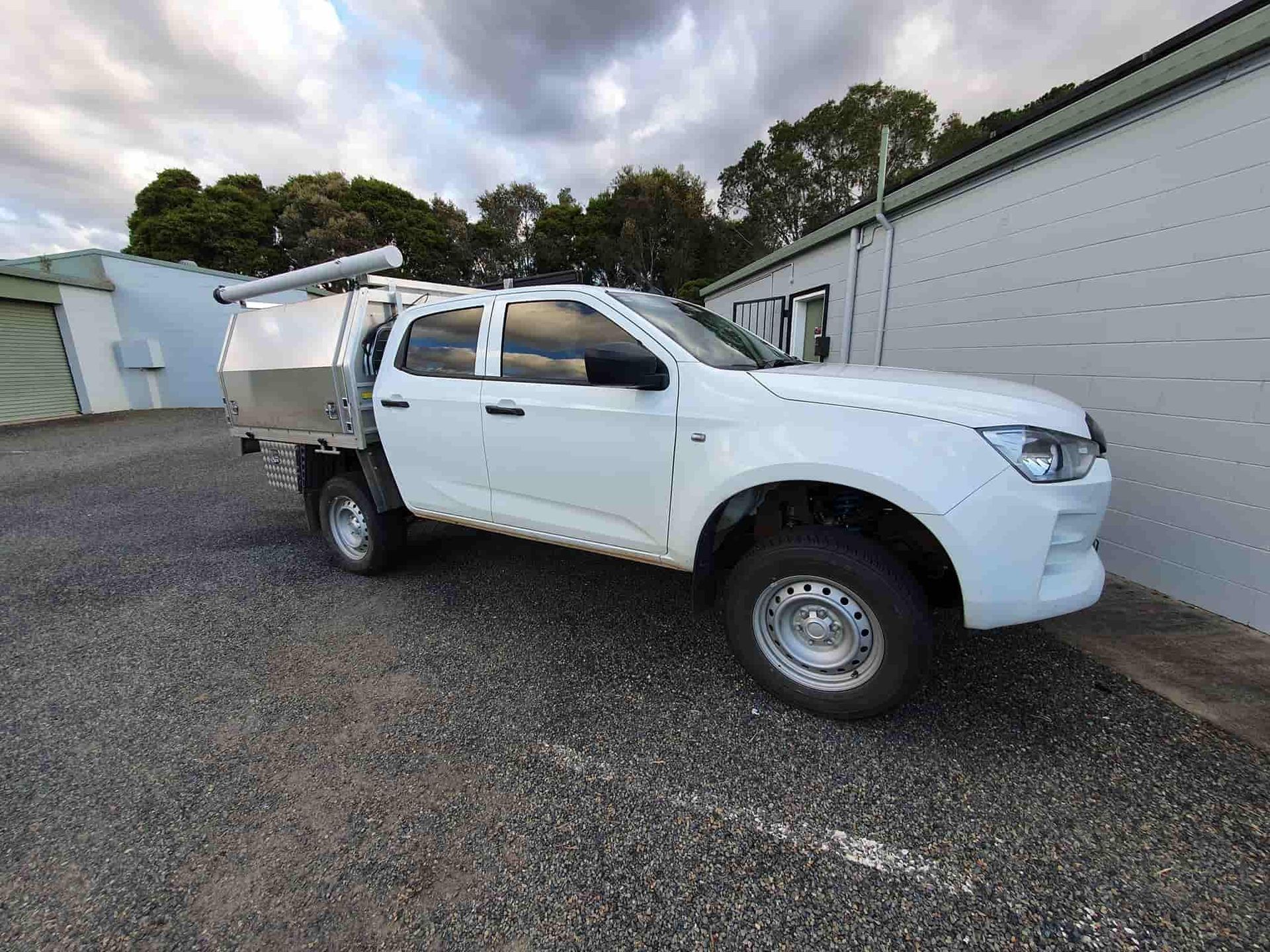 A White Truck With a Canopy is Parked in Front of a Building — OSP Automotive & Marine In Grafton, NSW