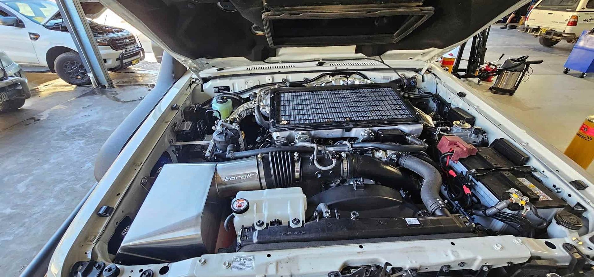 A White Car With the Hood Open is Sitting in a Garage — OSP Automotive & Marine In Grafton, NSW