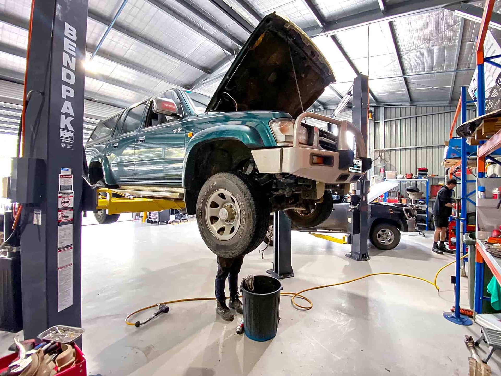 A Car is Being Worked on on a Lift in a Garage — OSP Automotive & Marine In Grafton, NSW