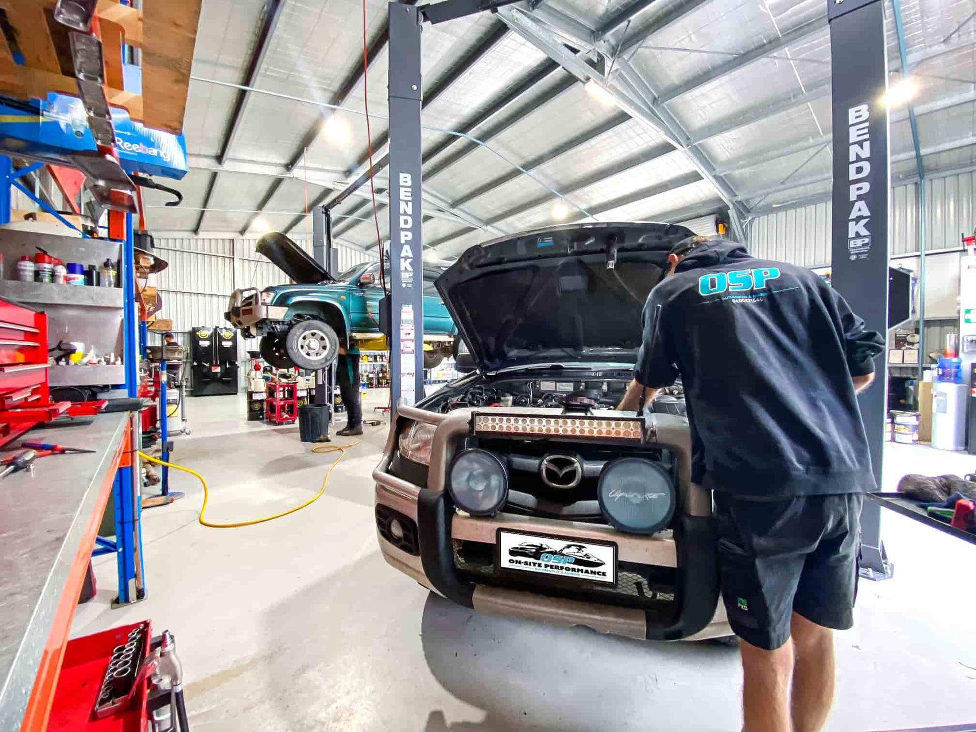 A Man is Working on a Car in a Garage With the Hood Up — OSP Automotive & Marine In Grafton, NSW