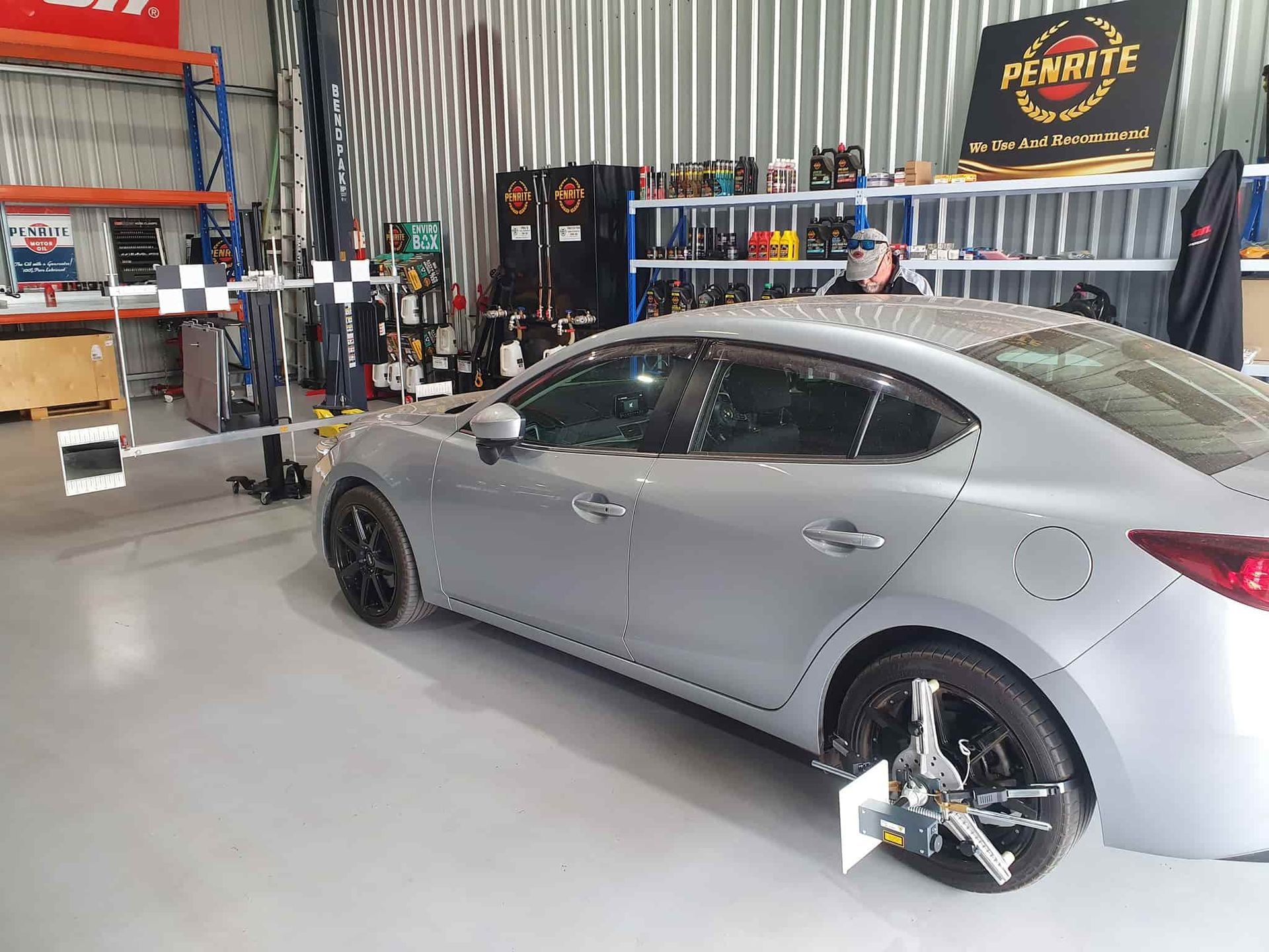 A Silver Car is Sitting in a Garage Next to a Checkered Flag — OSP Automotive & Marine In Grafton, NSW