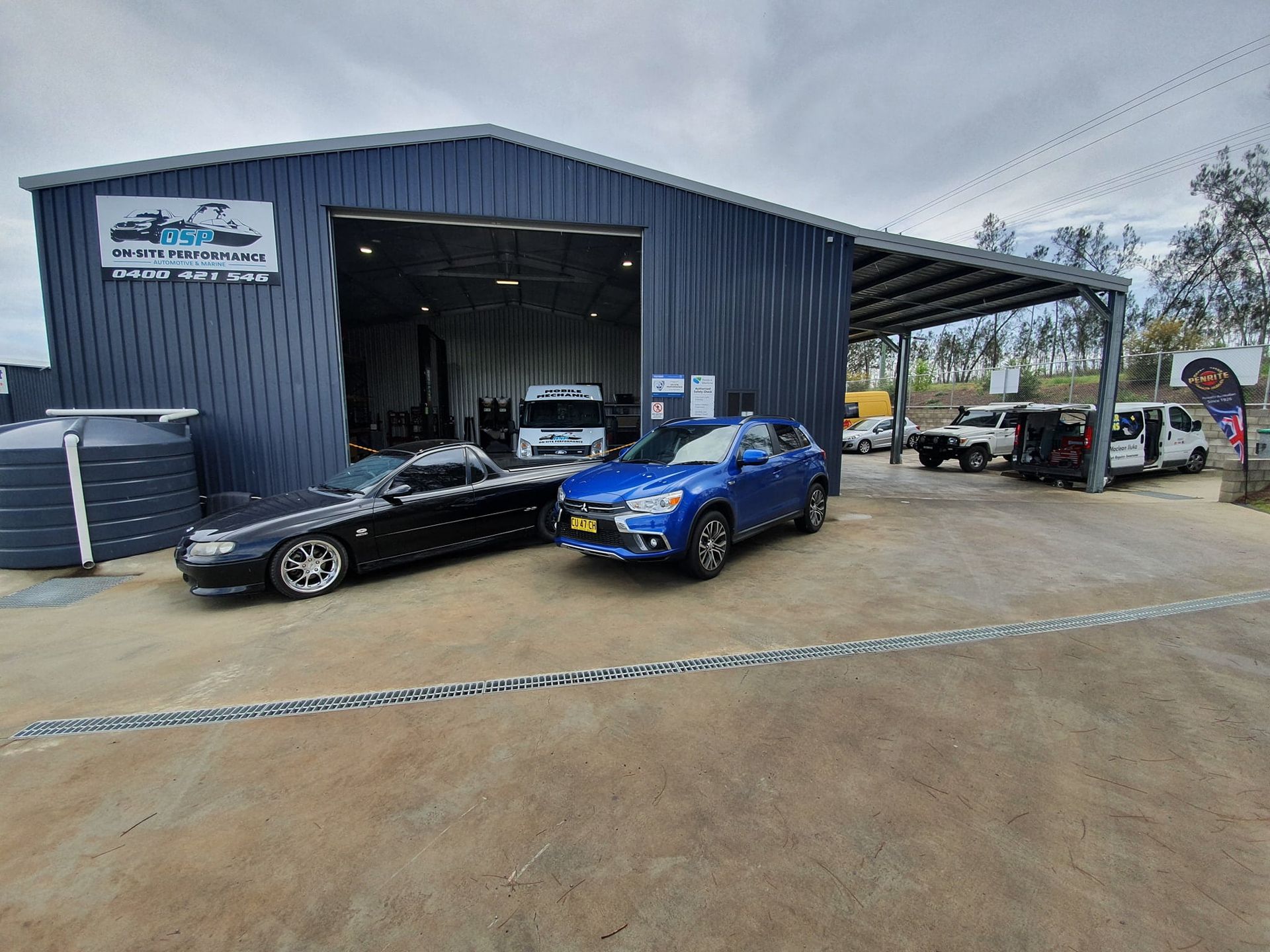 A Black Car and a Blue Car Are Parked in Front of a Garage — OSP Automotive & Marine In Grafton, NSW