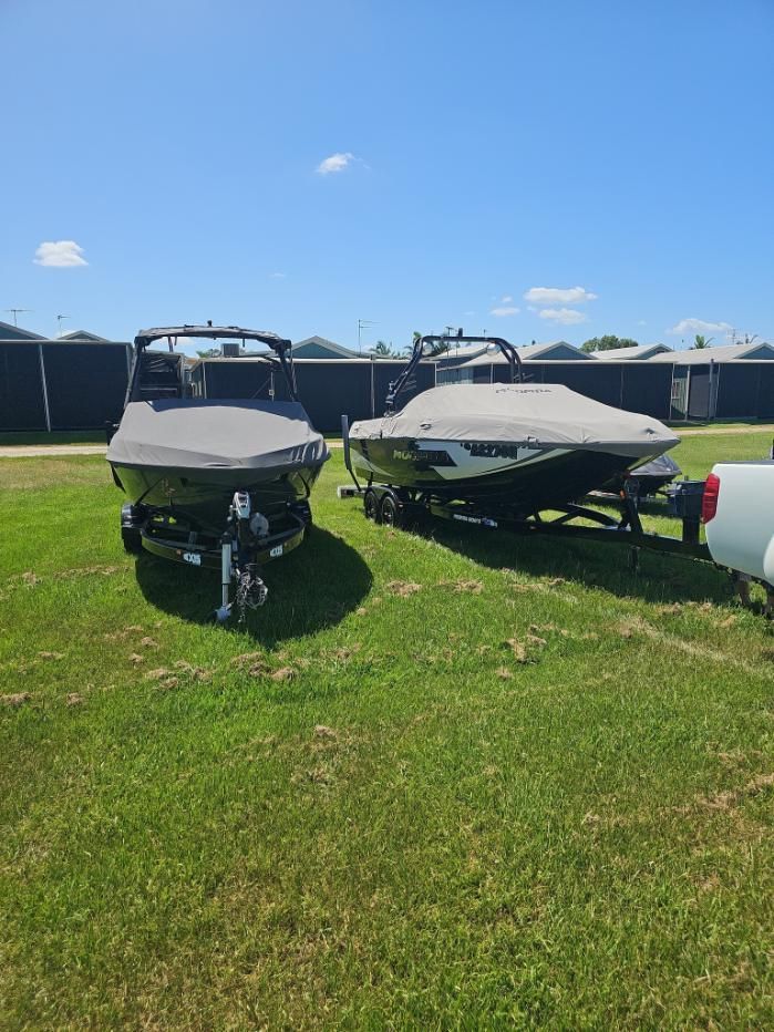 Two Boats Are Parked in a Grassy Field Next to a Truck — OSP Automotive & Marine In Grafton, NSW