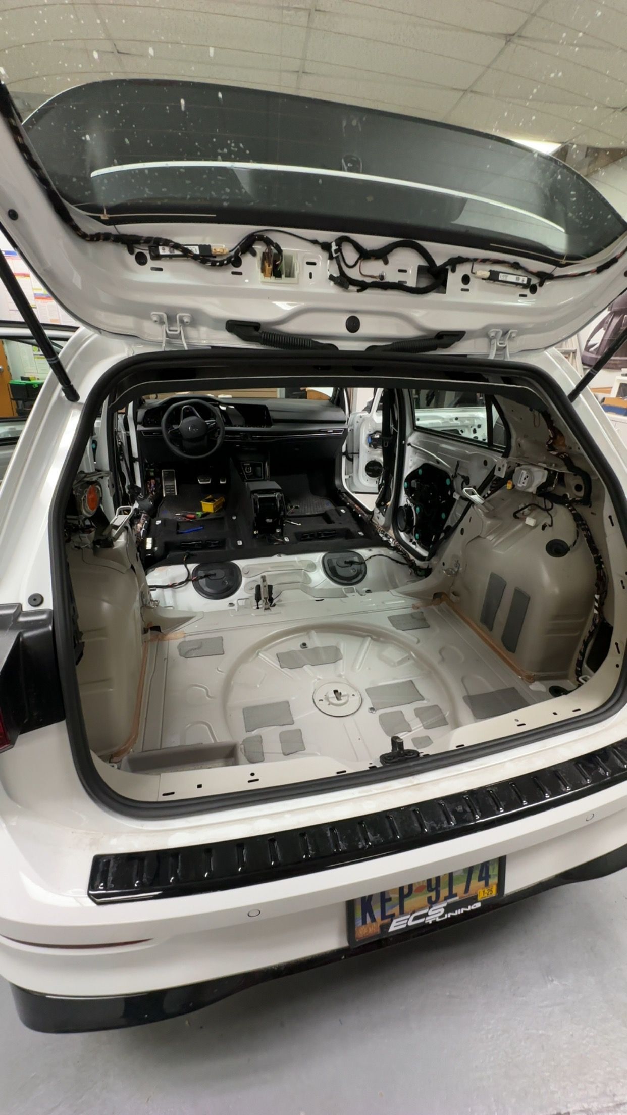 A black car is parked in front of an auto sound store