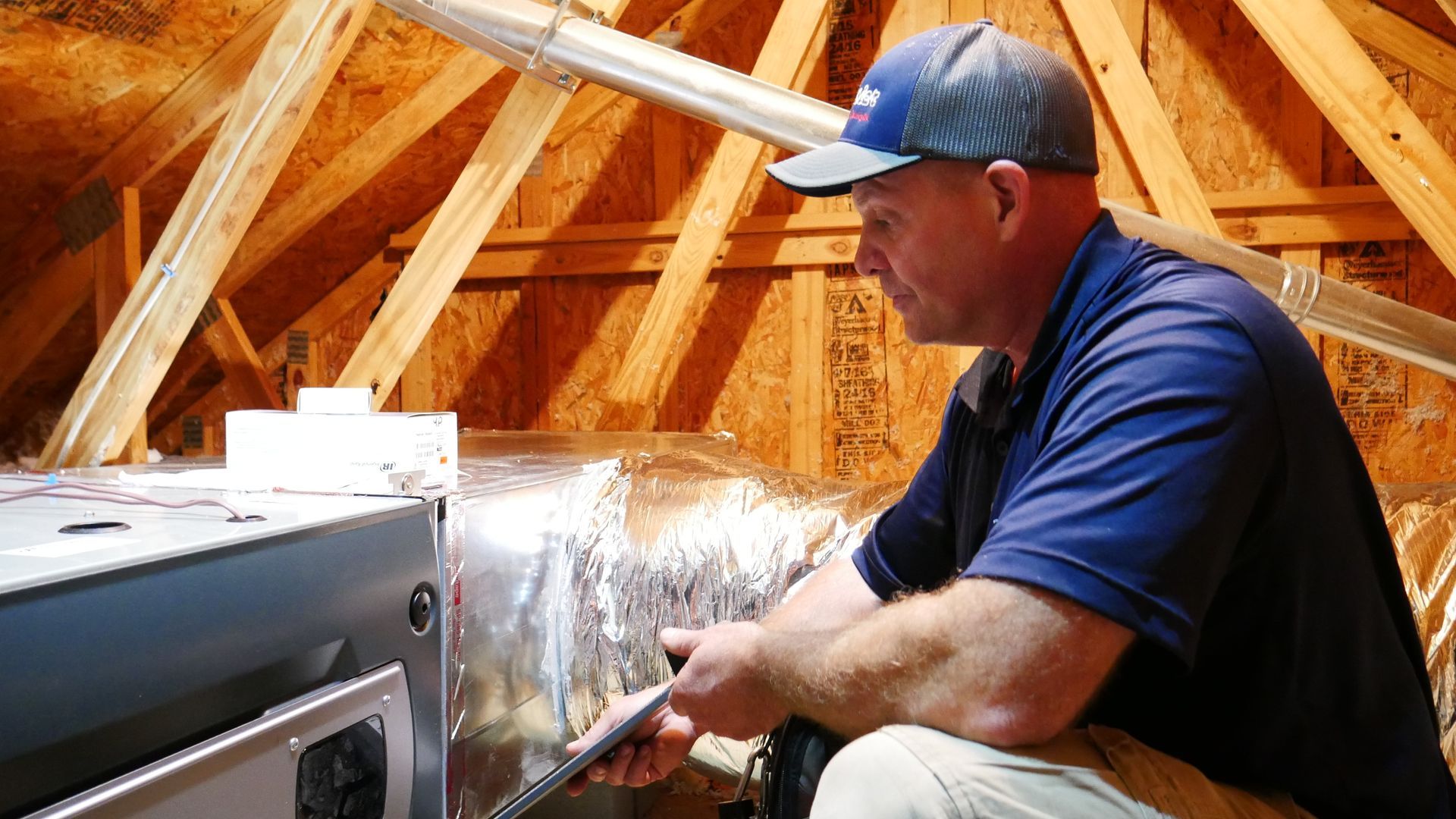 a man is working on an air conditioner in the attic of a house .