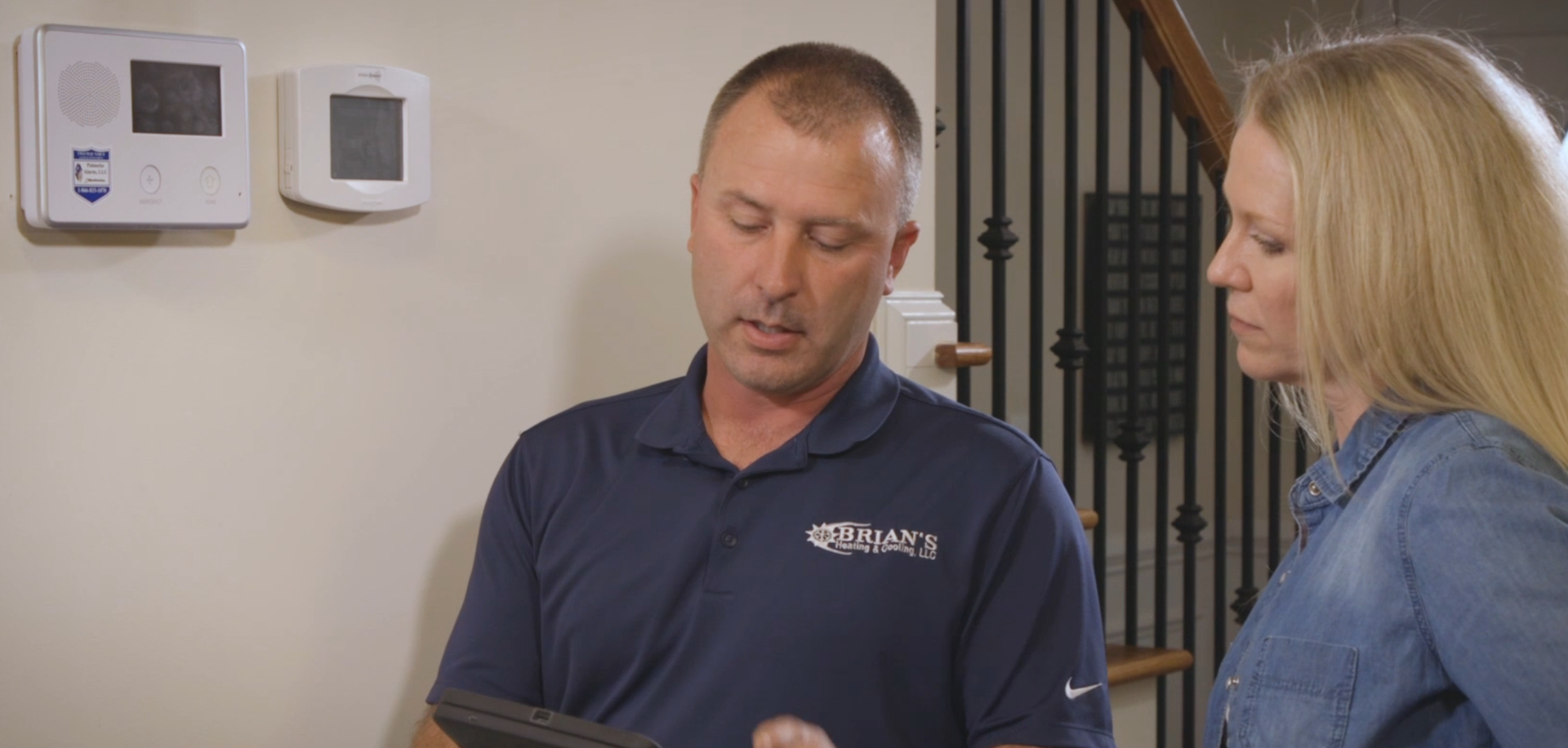 a man and a woman are looking at a tablet .