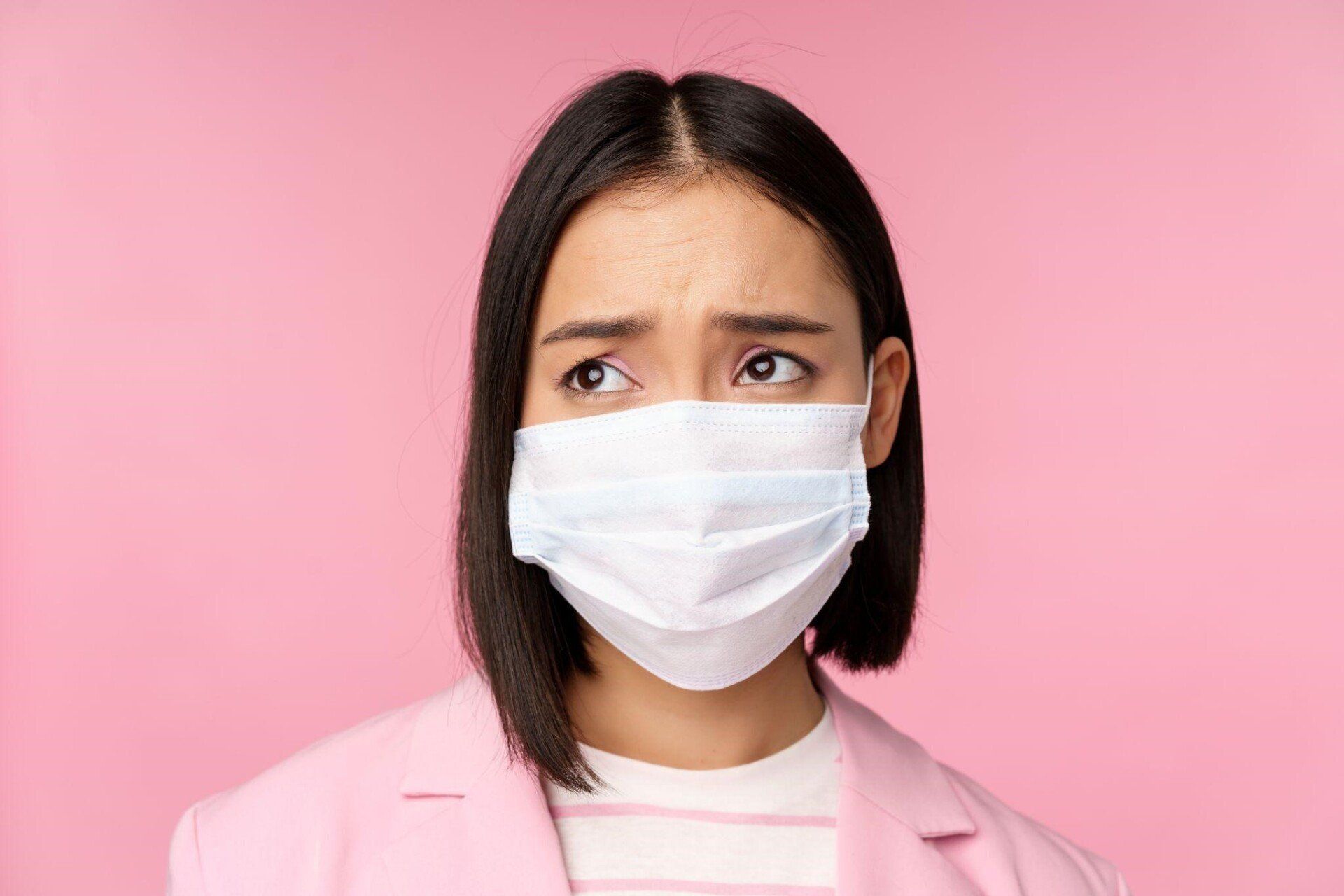 a woman in pink wearing a white face mask