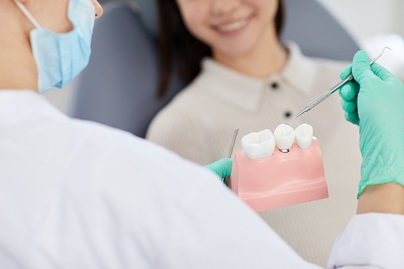 a dentist showing a patient how dental implants work