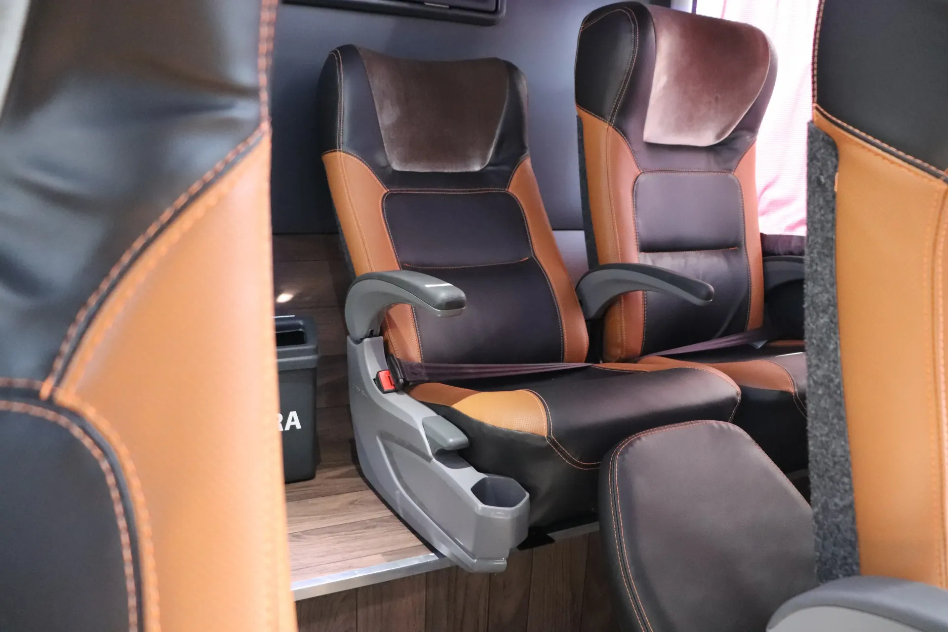 O interior de um ônibus com assentos convencionais